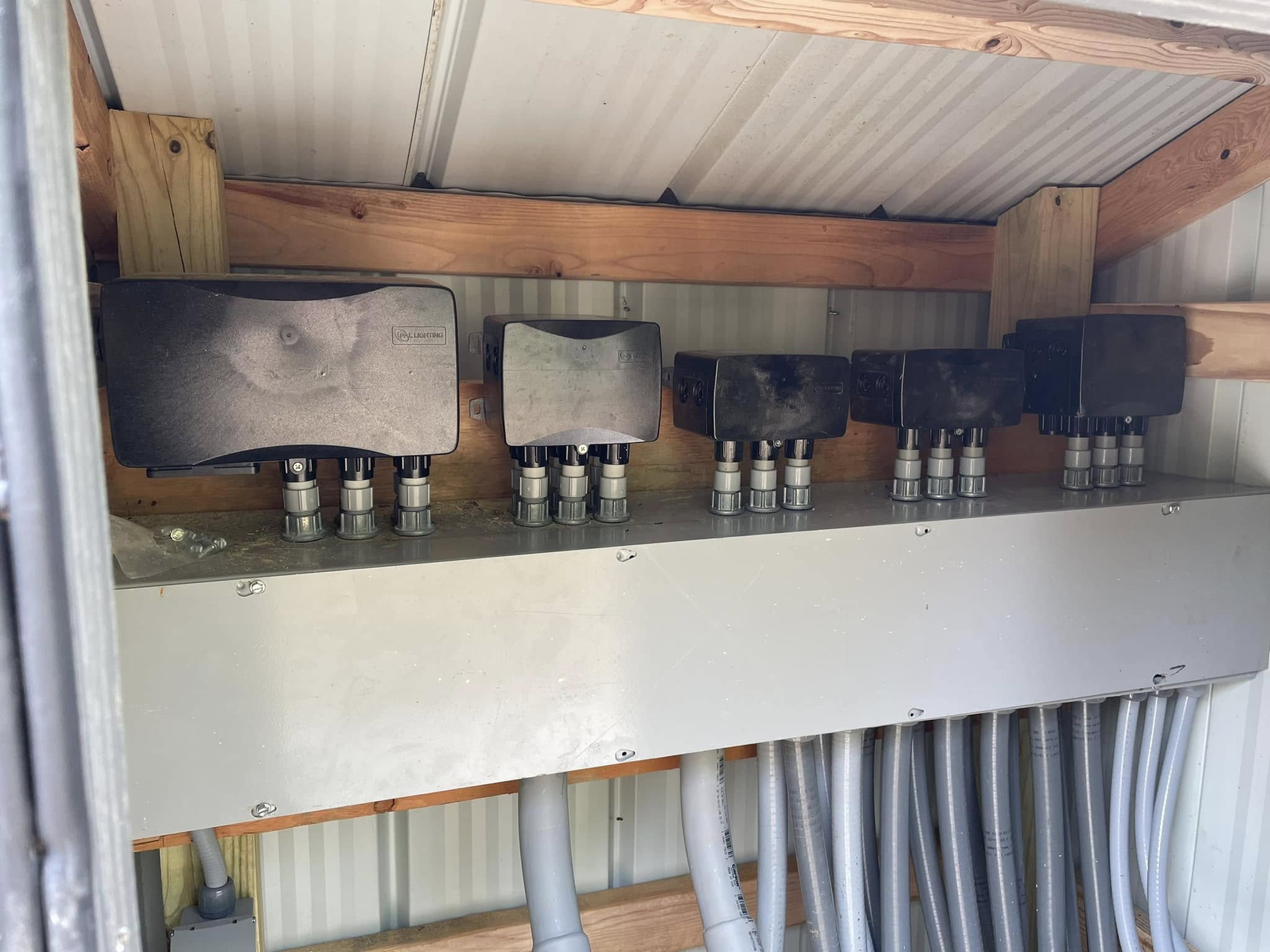 Electrical panel with multiple circuit breakers and wiring under a wooden roof structure