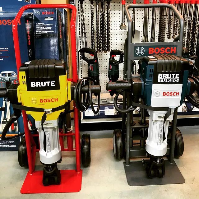 Two Bosch Brute jackhammers on display, one red and one black, in a store aisle