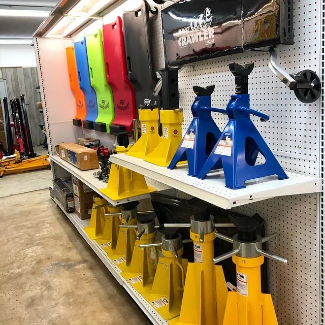 Hardware store aisle with colorful jack stands and lifting equipment displayed on shelves