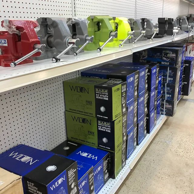 Store shelf displaying boxed power tools in red, gray, lime, and black packaging.