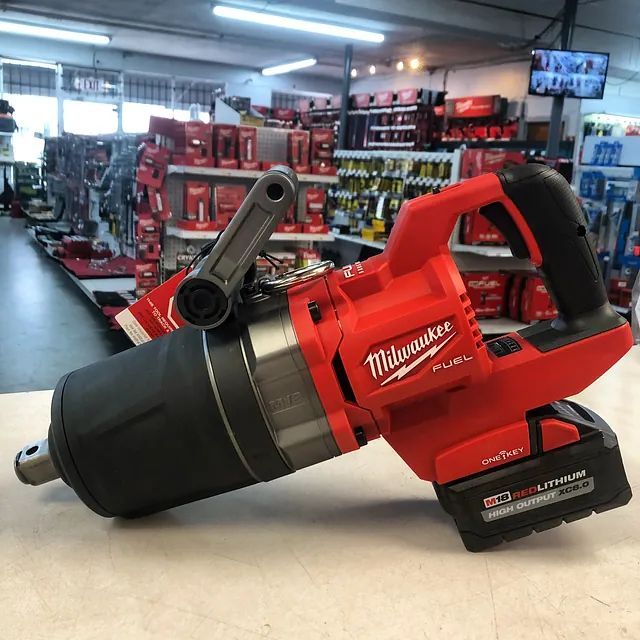 Red Milwaukee power drill on a store counter with tool shelves in the background