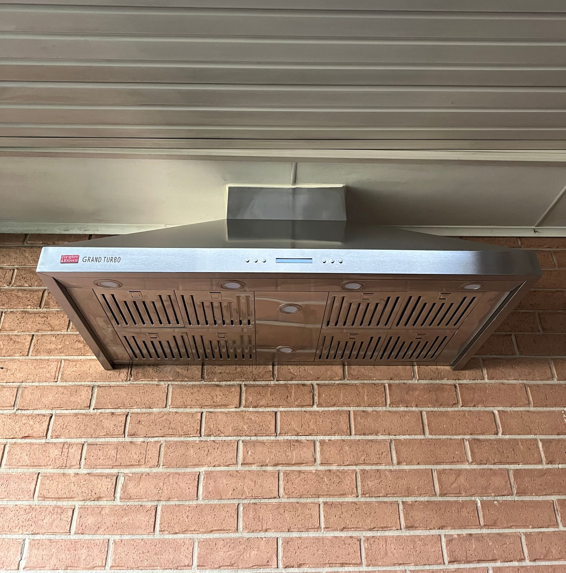 Brick wall with a mounted metal vent or air conditioner under a roof overhang — Deltech HVACR in Georgetown, NSW