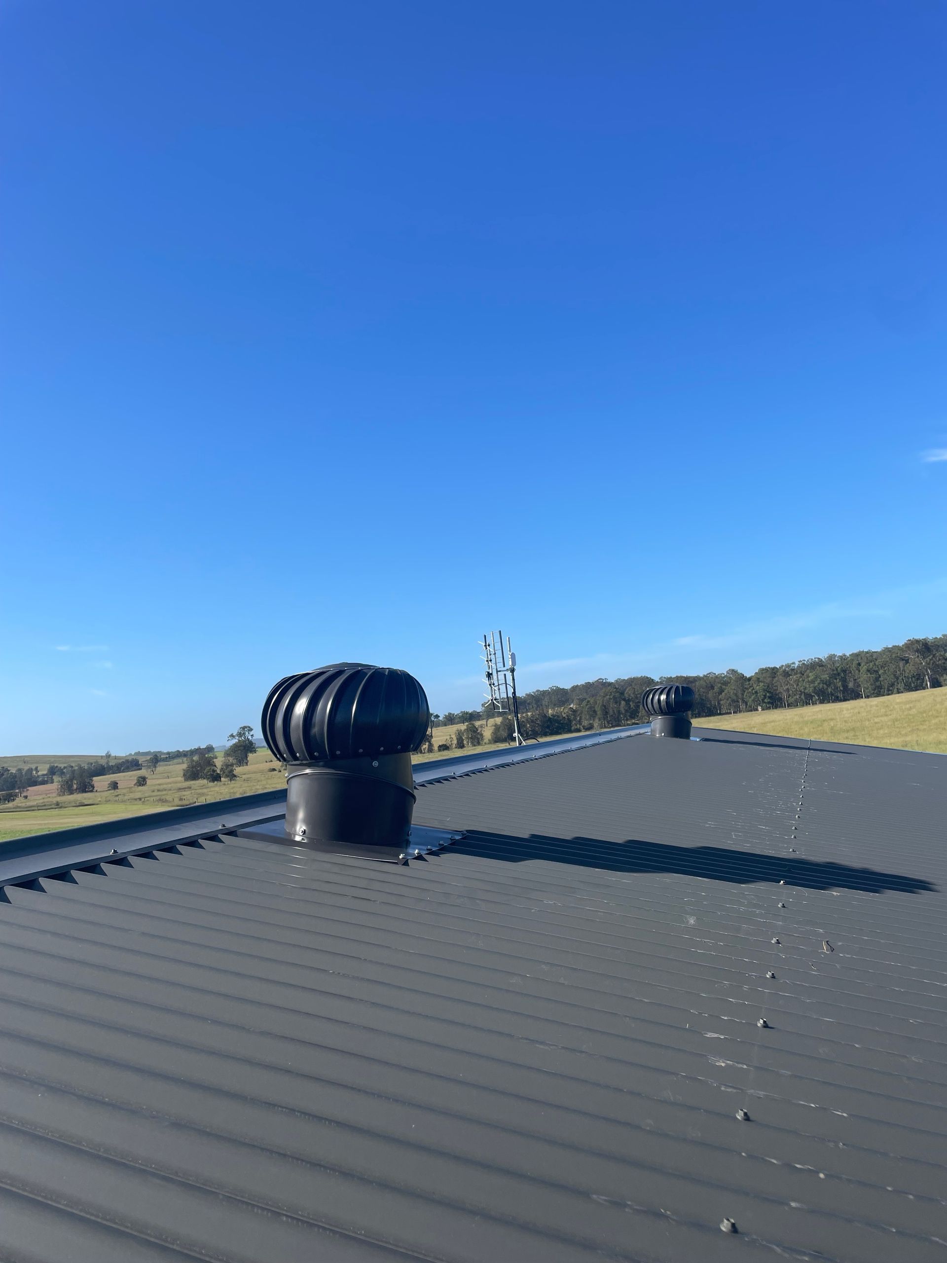 Rooftop With Black Vent Under a Clear Blue Sky — Deltech HVACR in Georgetown, NSW