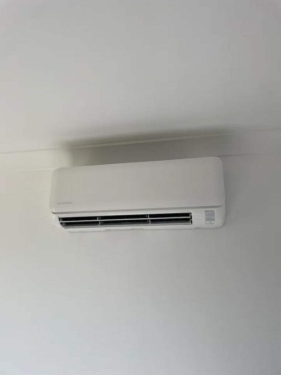 White Wall-mounted Air Conditioner Near the Ceiling on a Light-colored Wall — Deltech HVACR in Georgetown, NSW