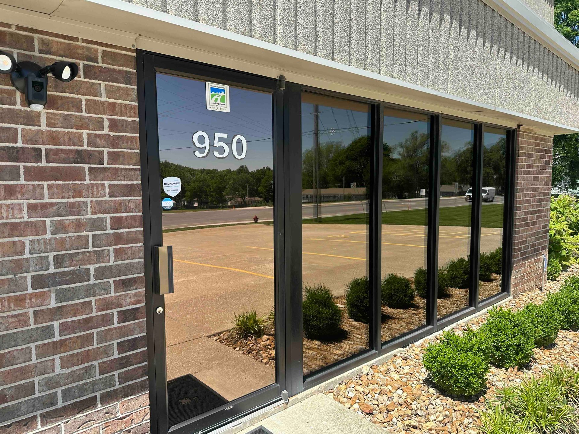 Building entrance with tinted windows. The address 950 is displayed on the door. Brick facade.