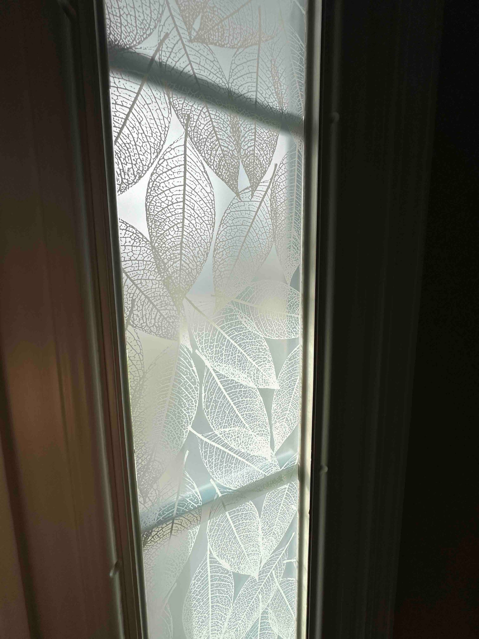 Frosted glass window panel with leaf design.