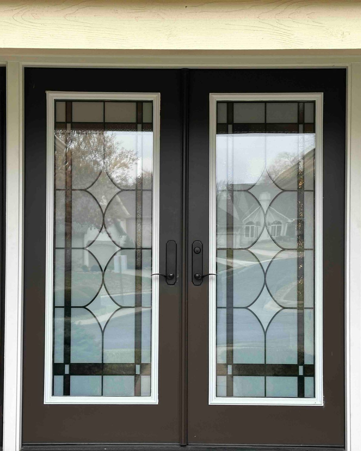 White front door with blue stained glass sidelights, heart decoration, and white trim.