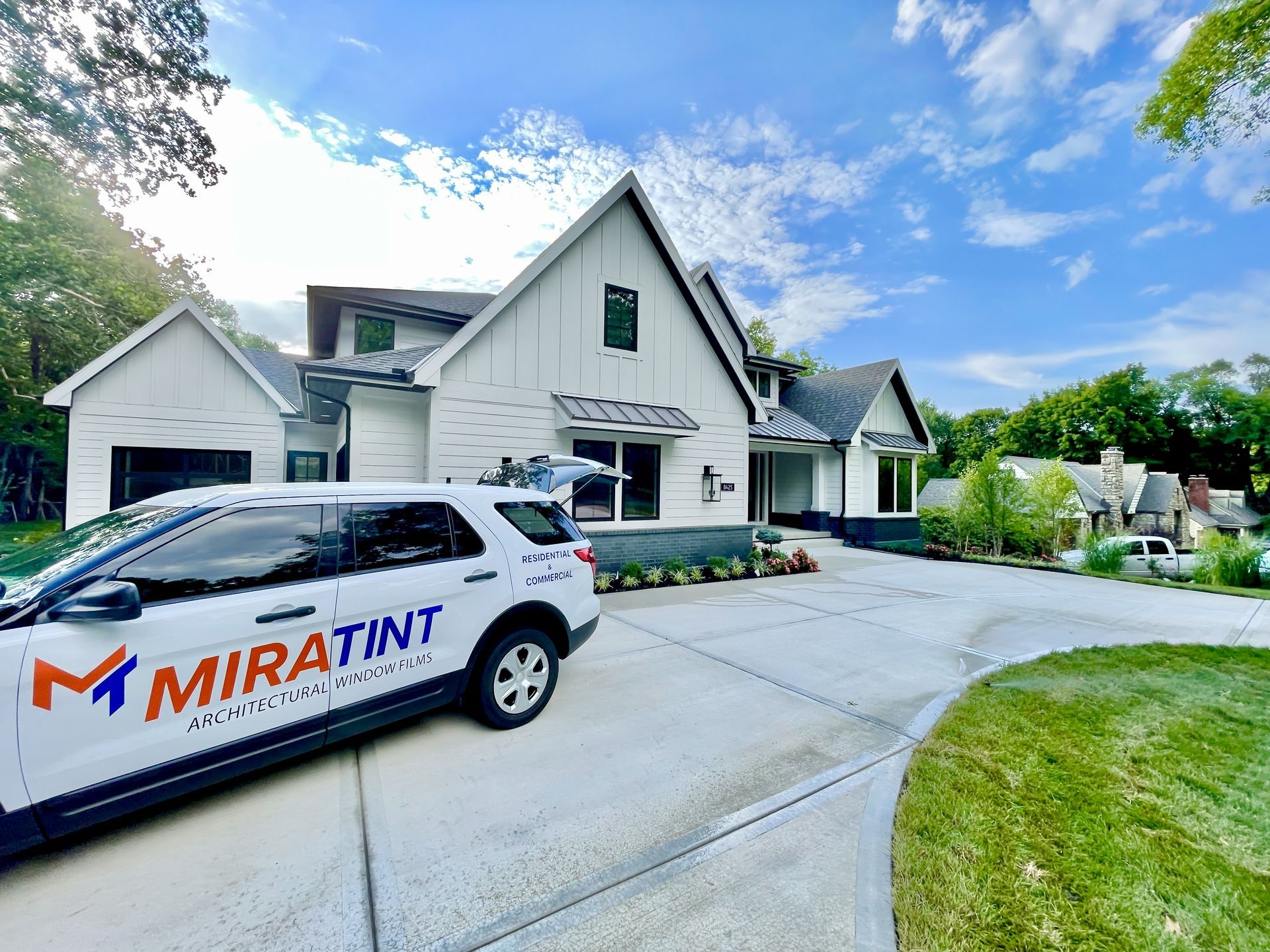 9 Benefits of Home Window Tinting White house with SUV parked in driveway;