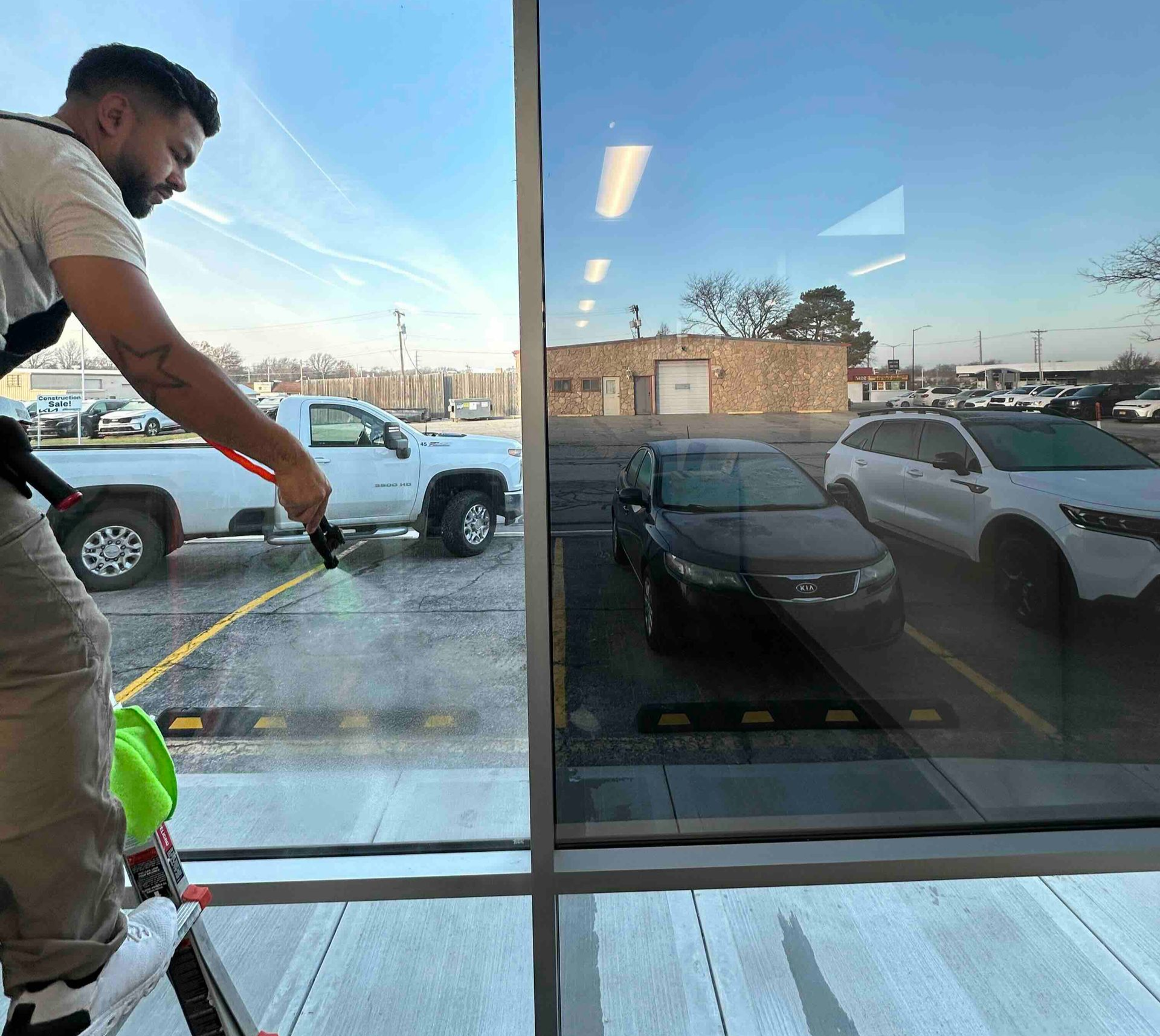 Applying film to a car side mirror with a squeegee and heat gun.