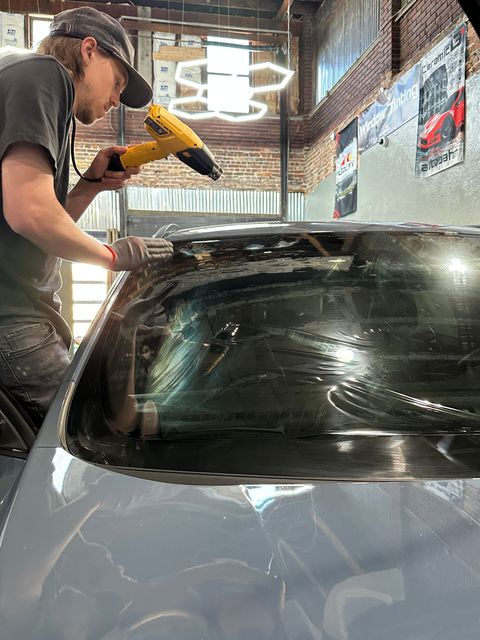 A car is being washed with foam in a garage.