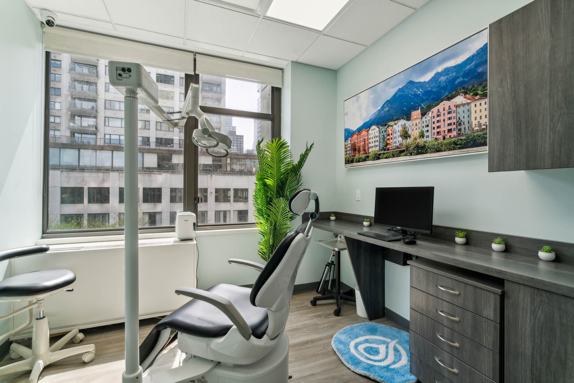 A dental office with a dental chair , desk and computer.