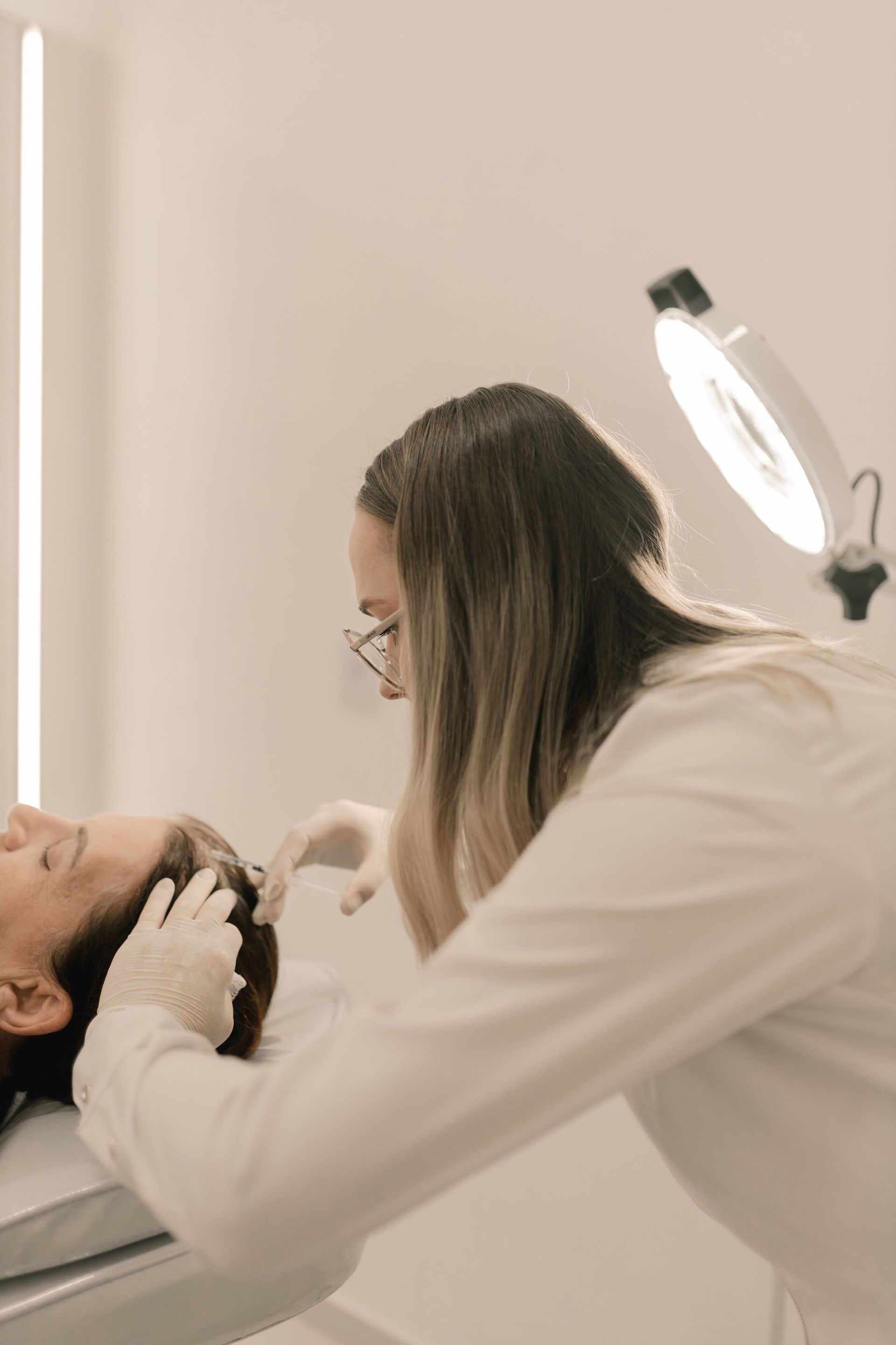 A clinician assessing scalp and hair density in a bright Manhattan clinic.