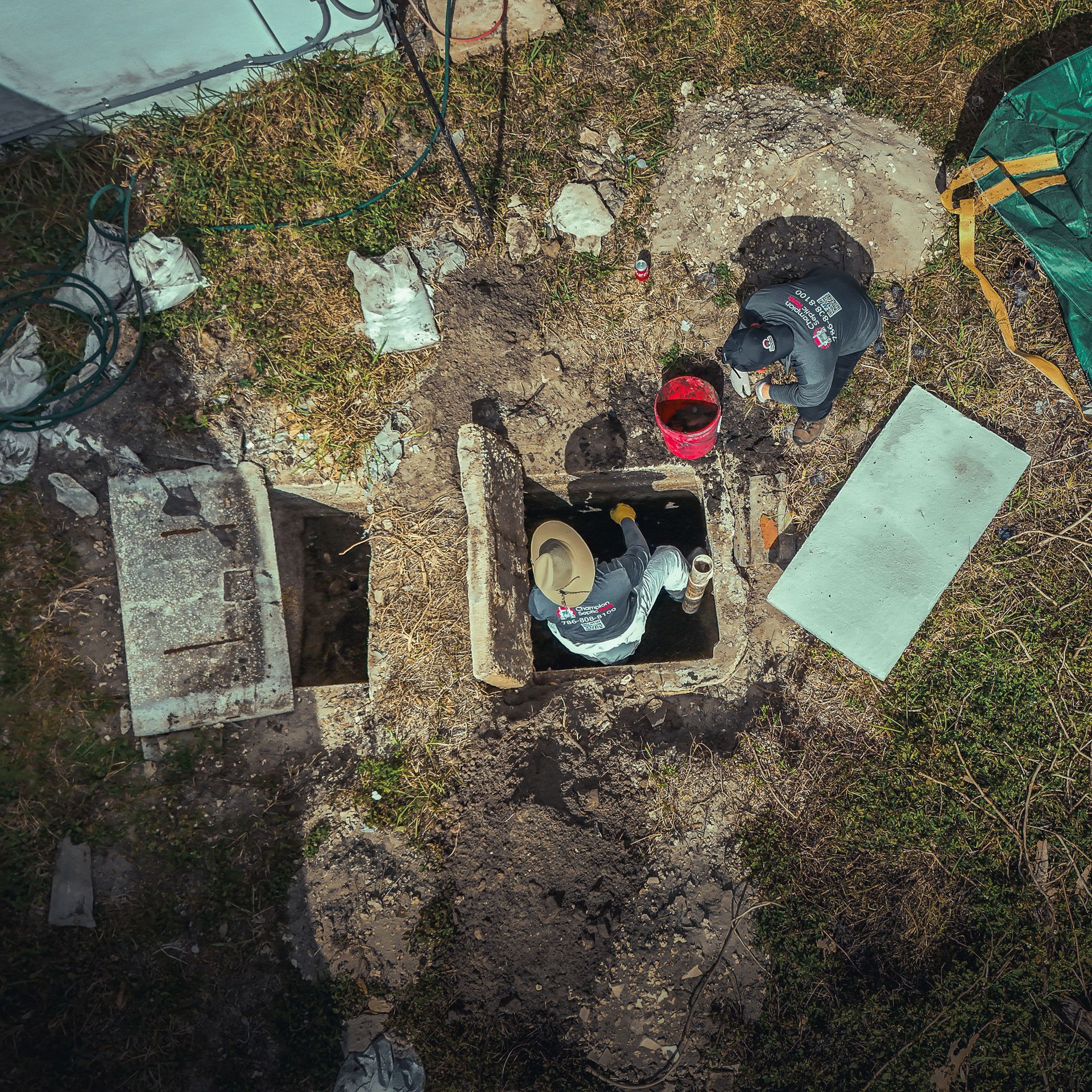 An aerial view of a man working on a septic tank.