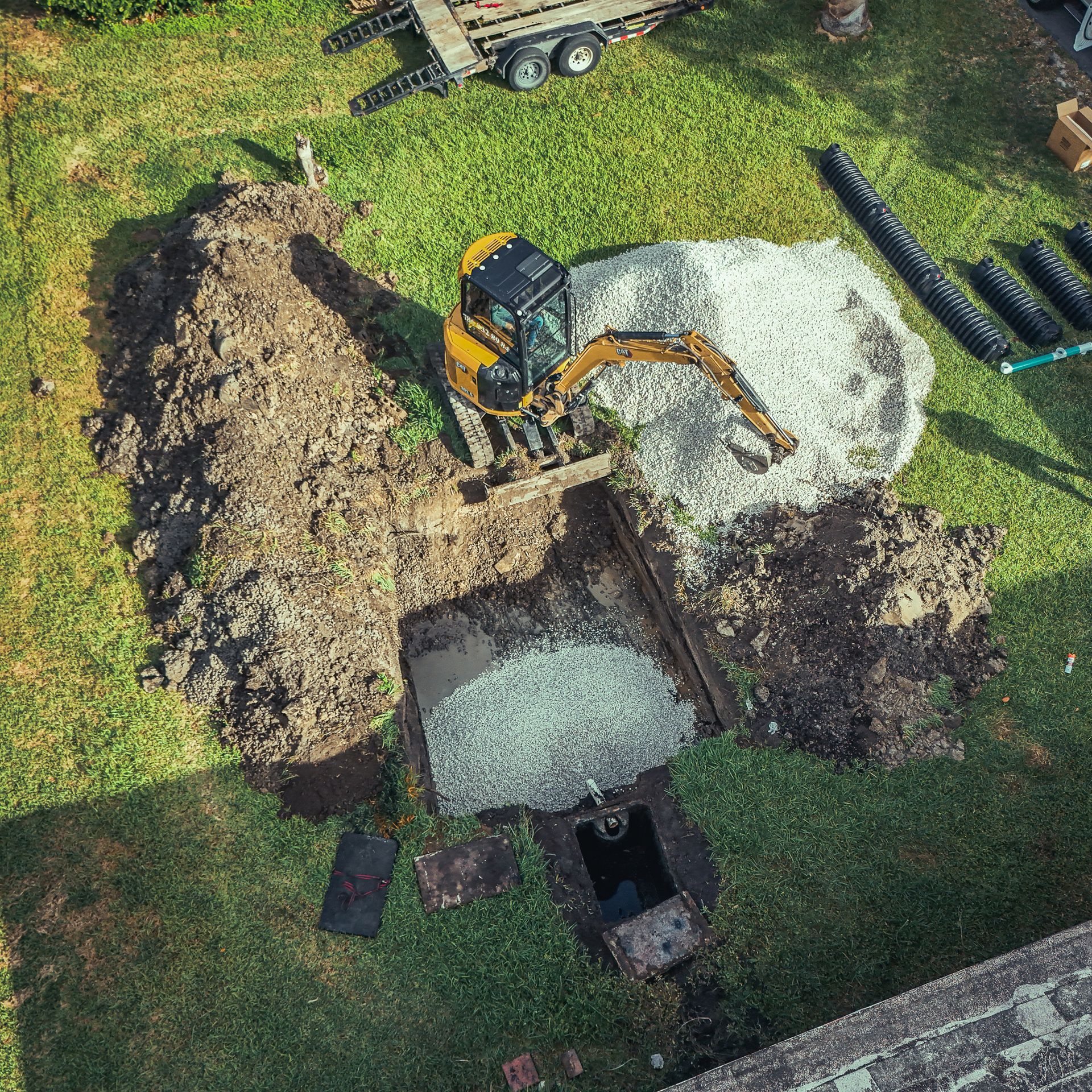 An aerial view of a construction site with a bulldozer digging a hole in the ground.