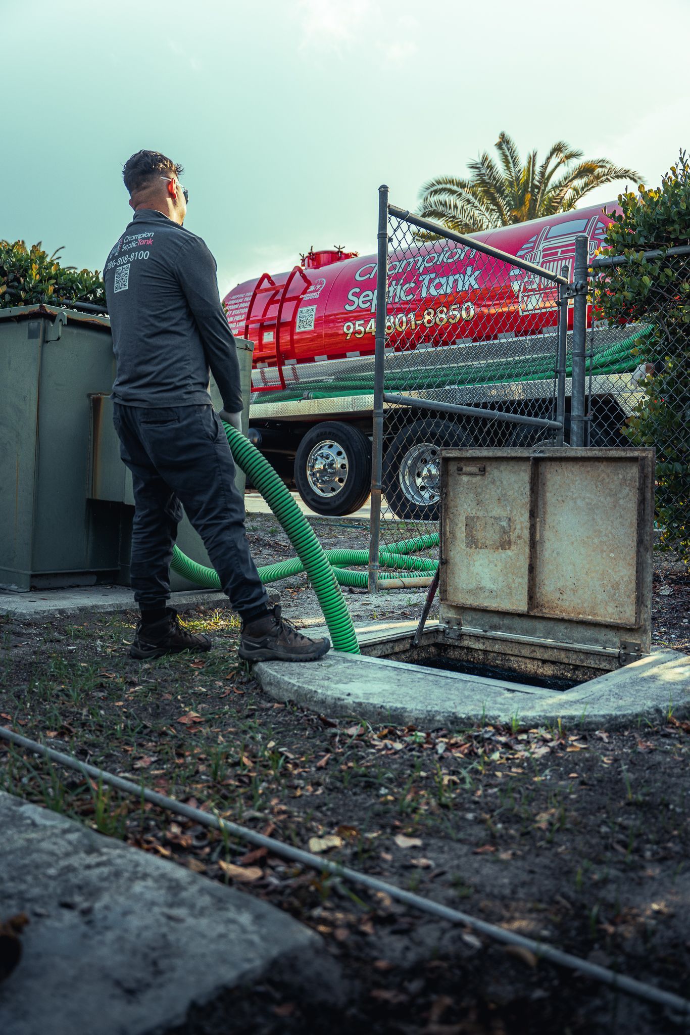 A man is pumping water into a septic tank.
