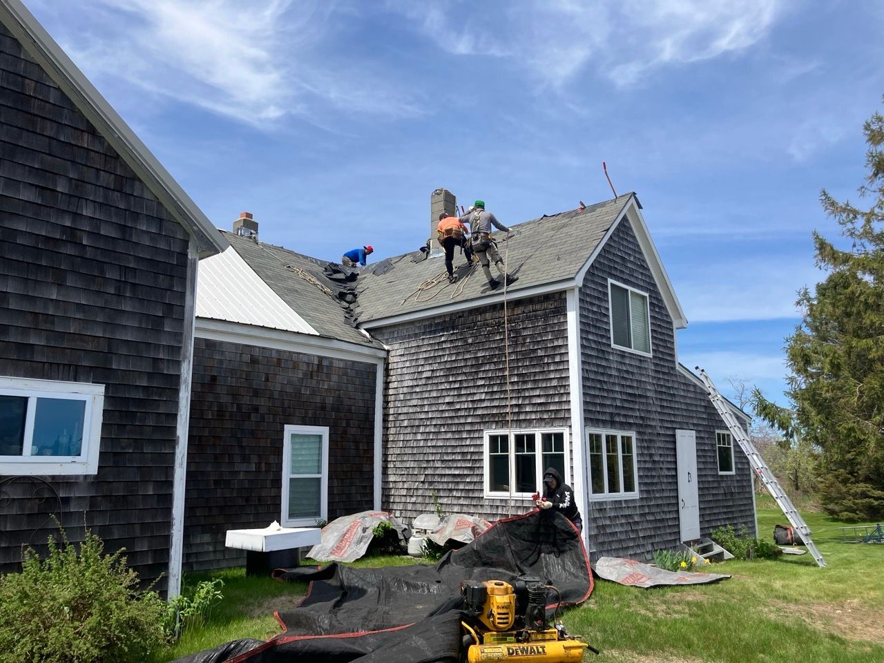 Two men are working on the roof of a house.