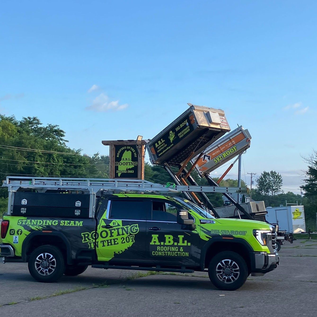 A green a.b.l. truck is parked in a parking lot