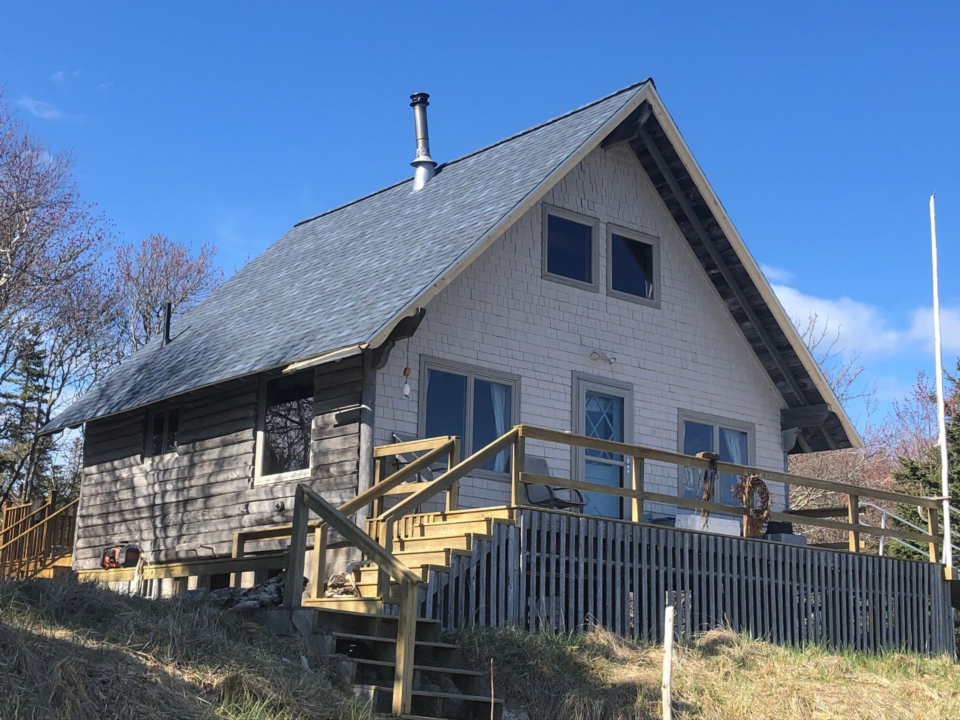 A small house with a wooden deck and stairs