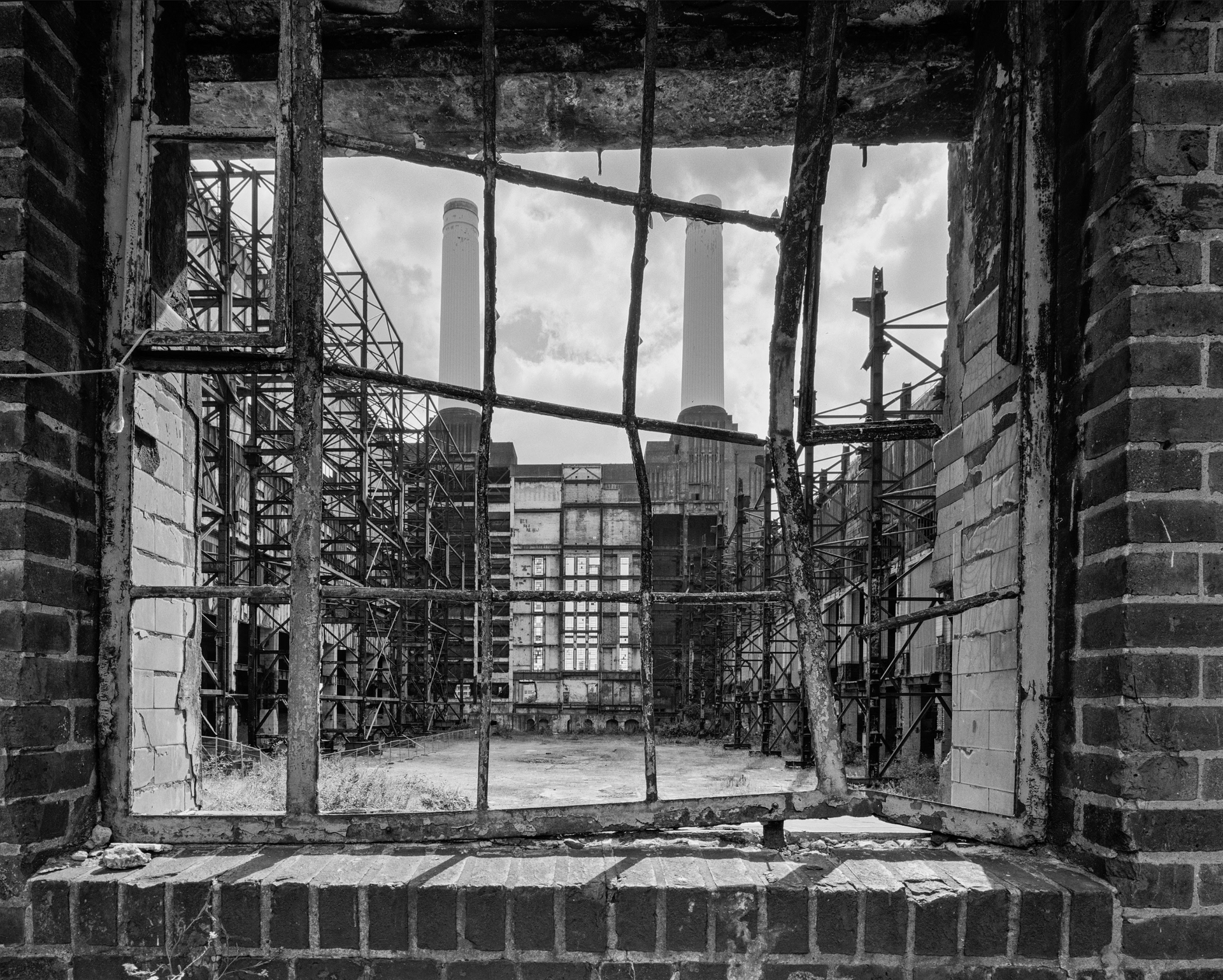 A black and white photo of a factory through a window
