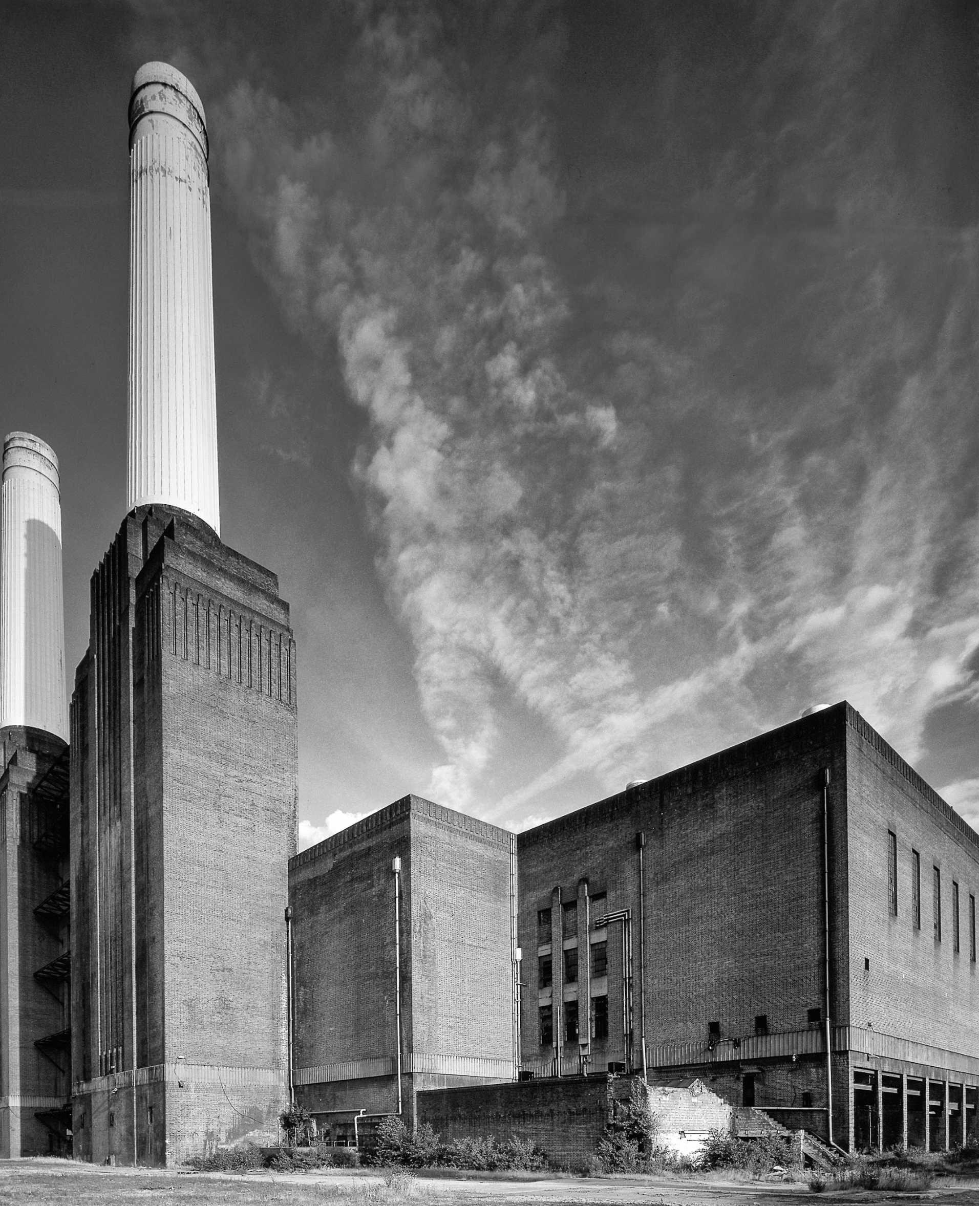 A black and white photo of a large brick building with chimneys.