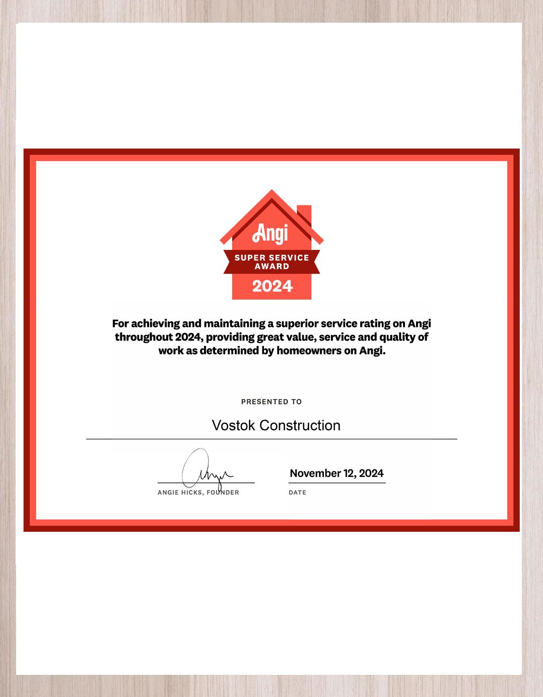 A certificate is sitting on a wooden table.