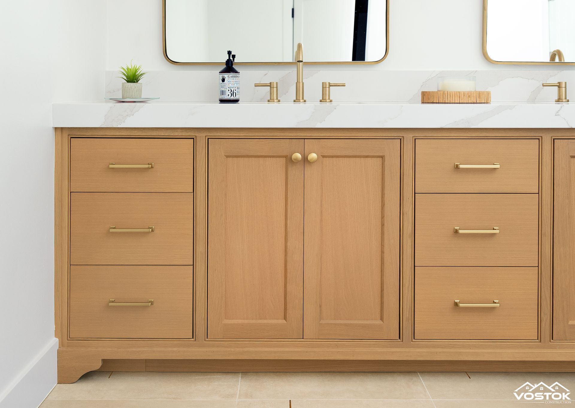 A bathroom vanity with two sinks and a mirror.