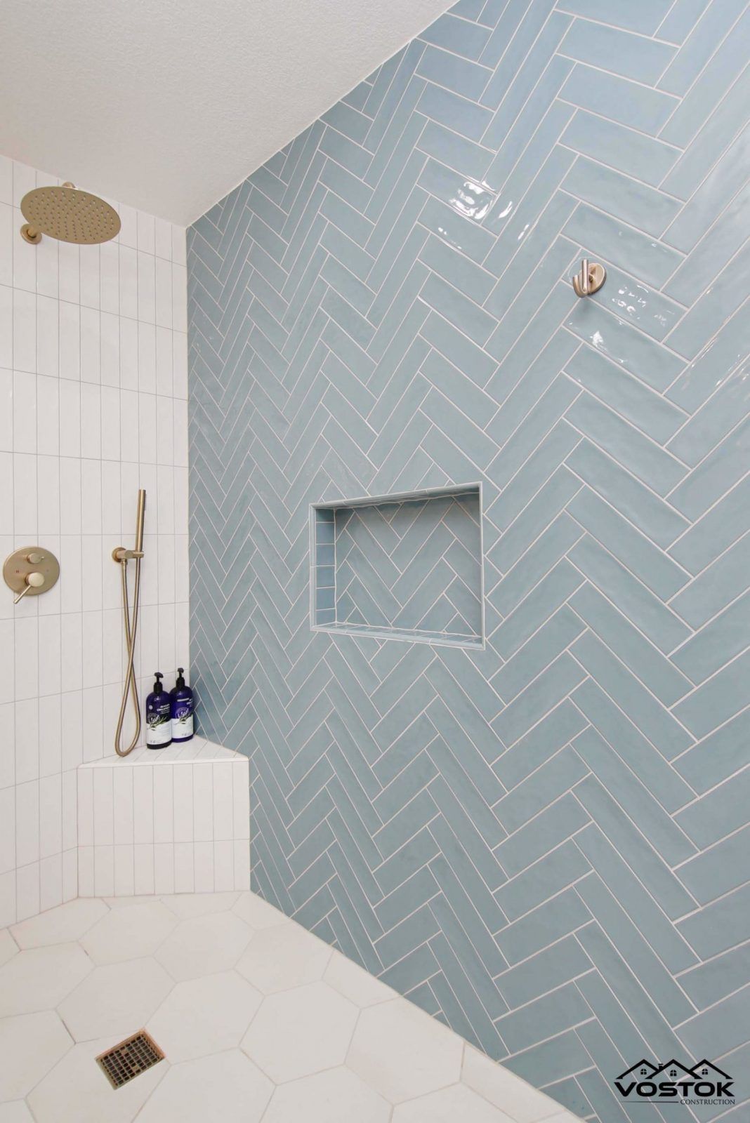 A bathroom with blue and white tiles and a shower.