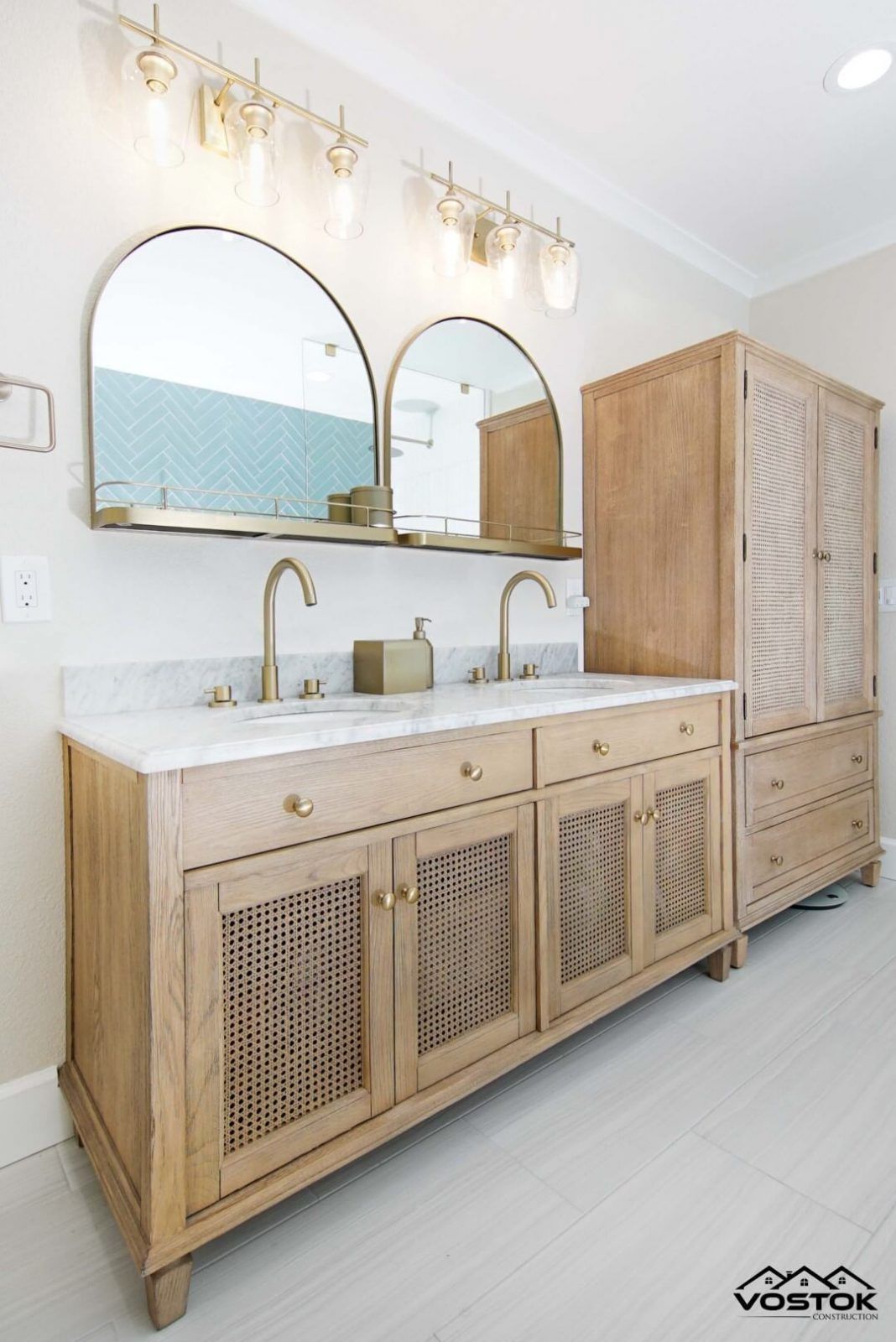 A bathroom with two sinks , two mirrors and a cabinet.