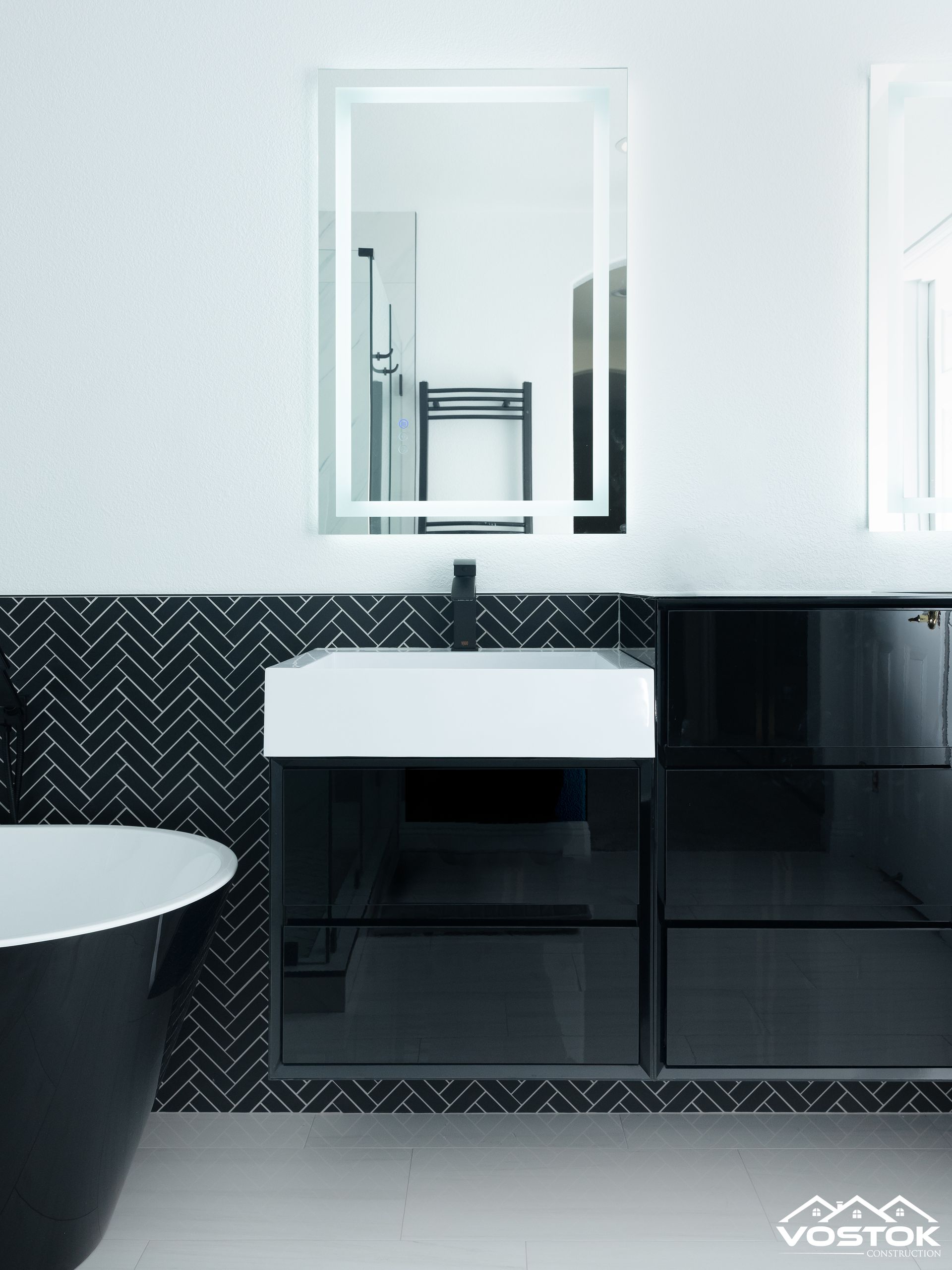 A bathroom with black tiles and a white sink