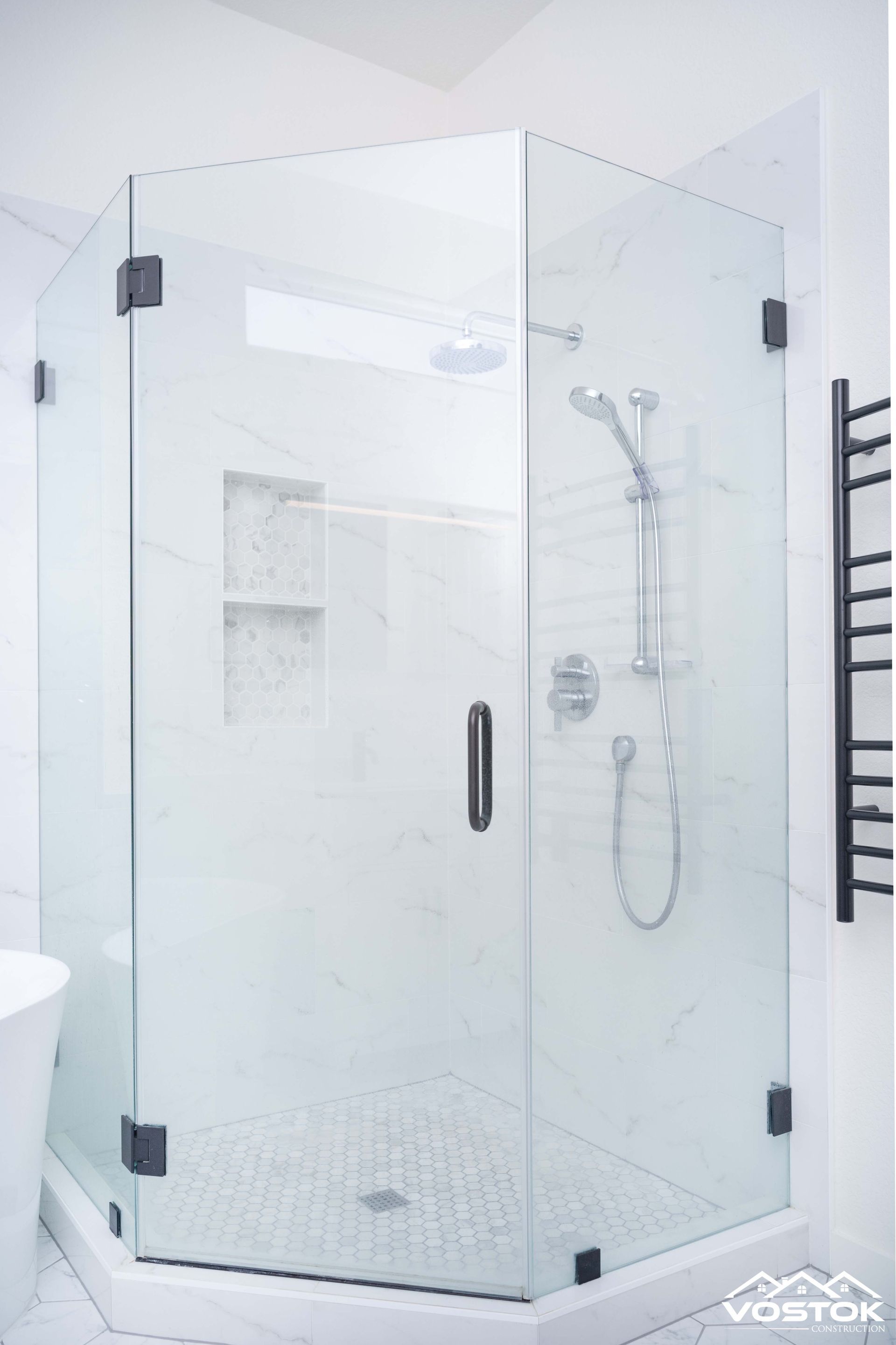 A bathroom with a shower stall and a shower head.