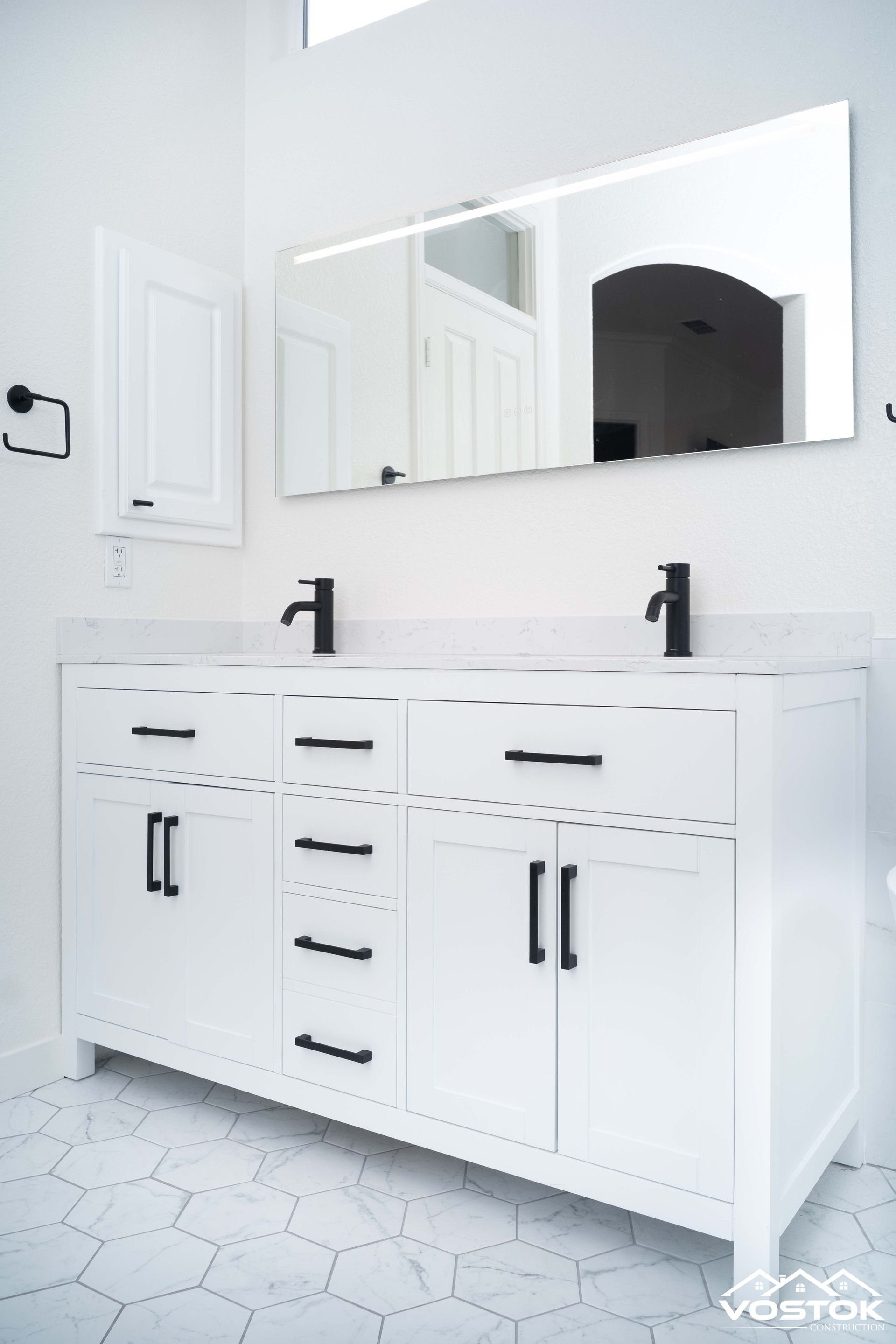 A bathroom with two sinks and a mirror.