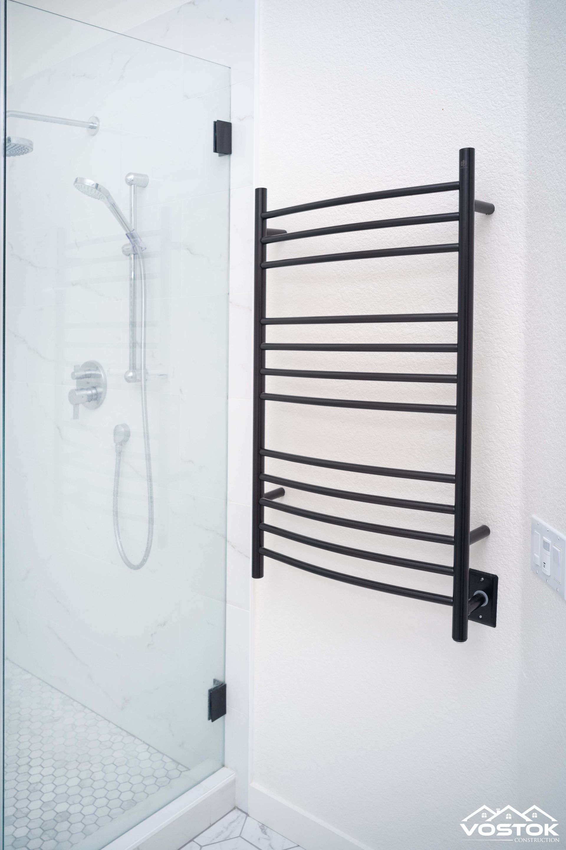 A bathroom with a towel rack and a shower stall.