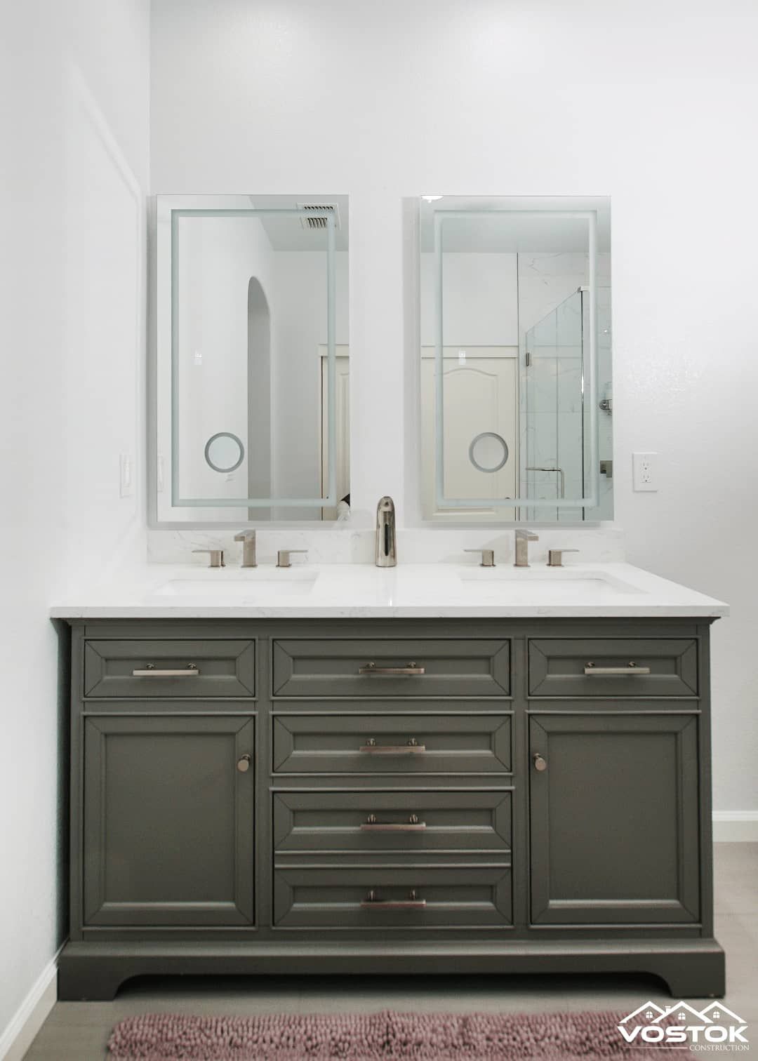 A bathroom vanity with two sinks and two mirrors