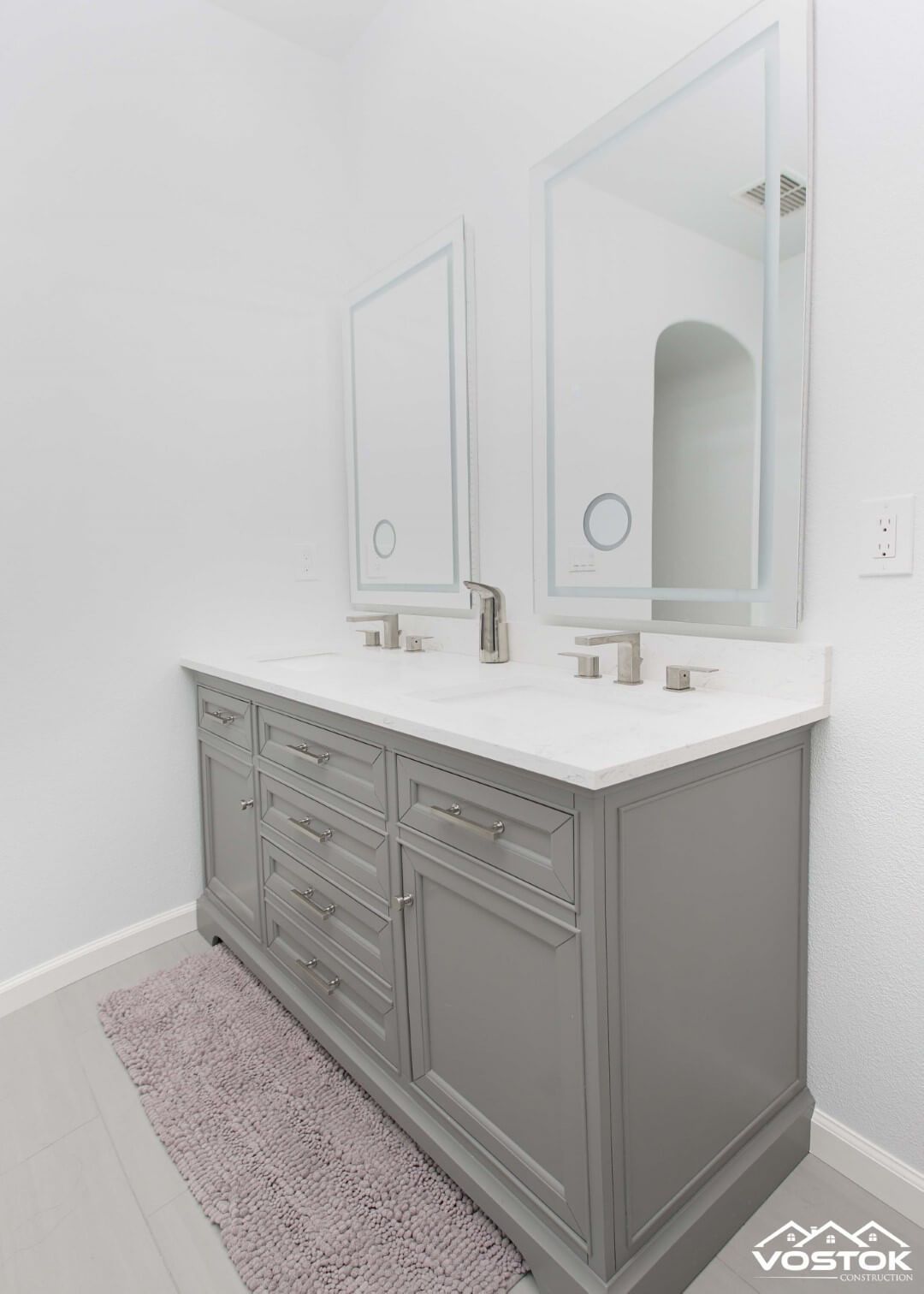 A bathroom vanity with two sinks and two mirrors.