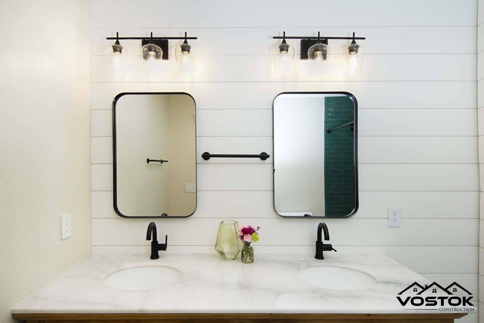 A bathroom with two sinks and two mirrors on the wall.