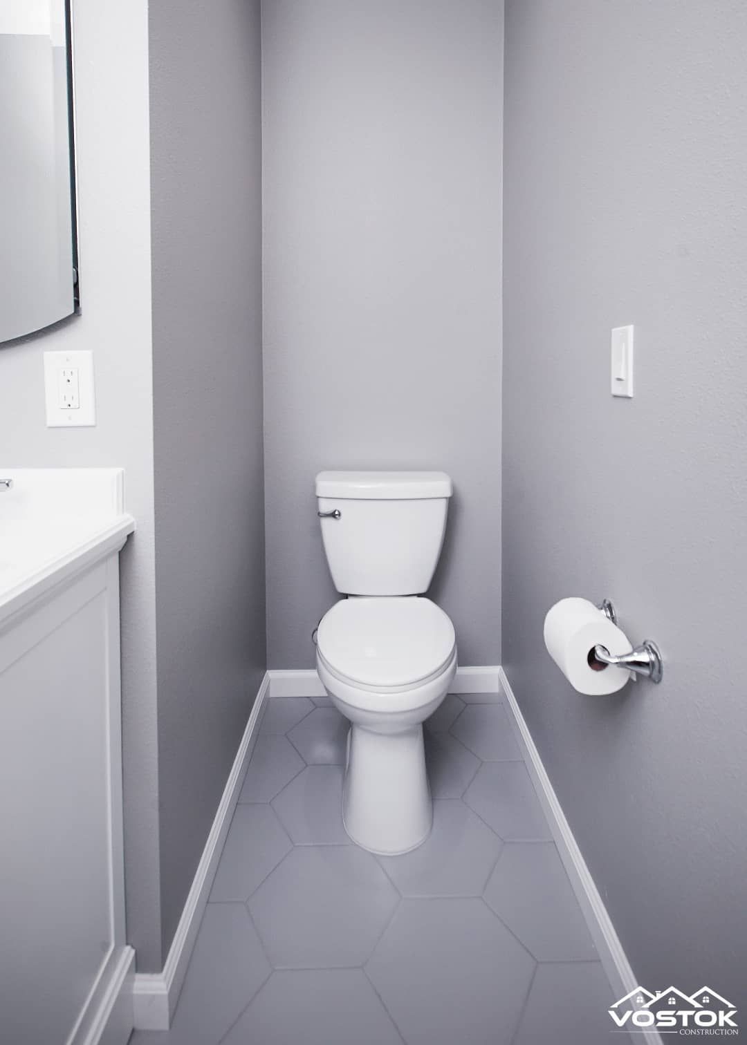 A small bathroom with a toilet and a paper towel holder.