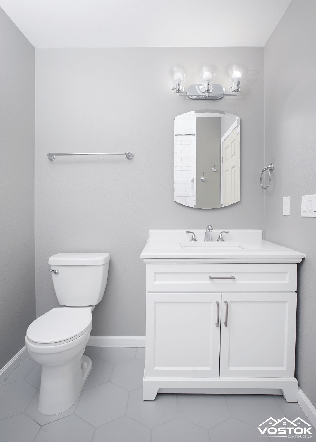A bathroom with a toilet a sink and a mirror