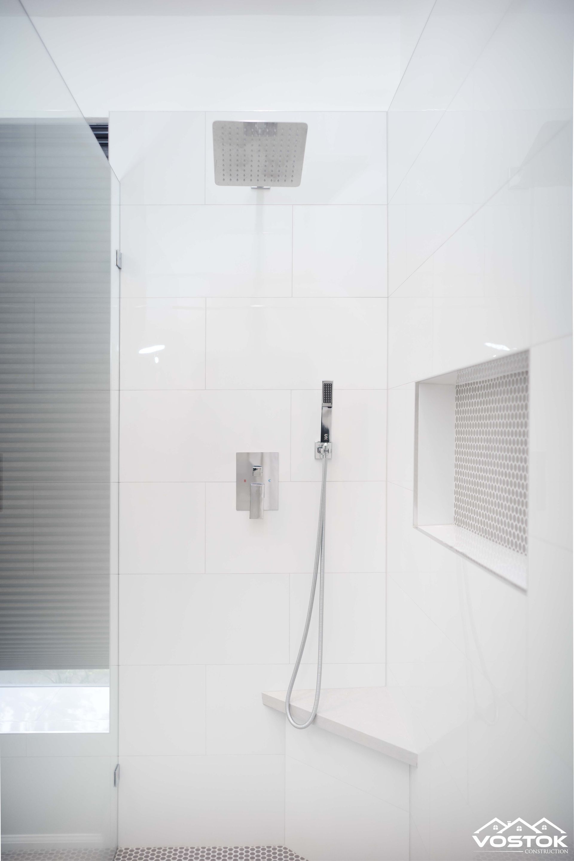 A shower with a shower head and a shower head in a bathroom.
