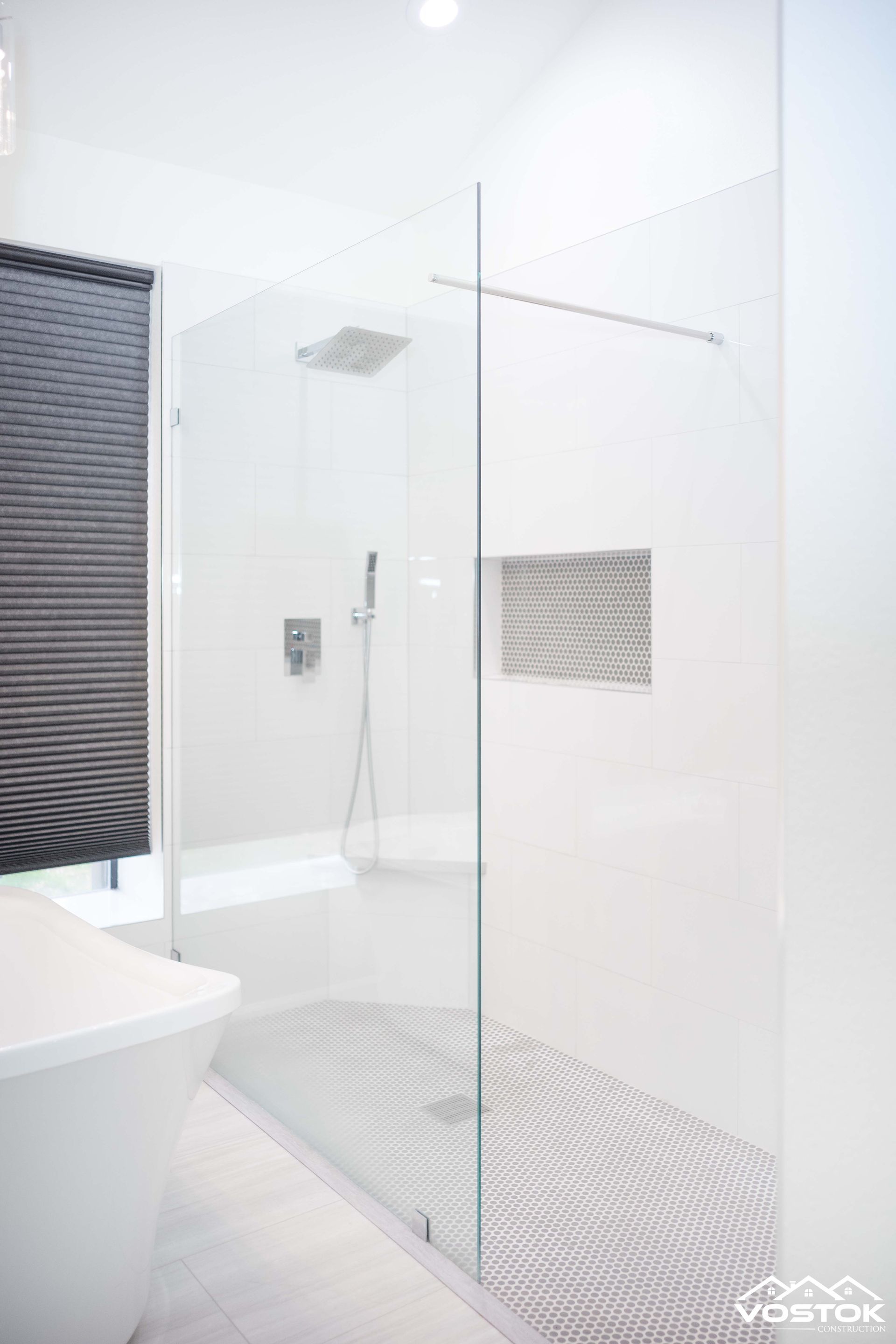 A bathroom with a walk in shower and a bathtub.