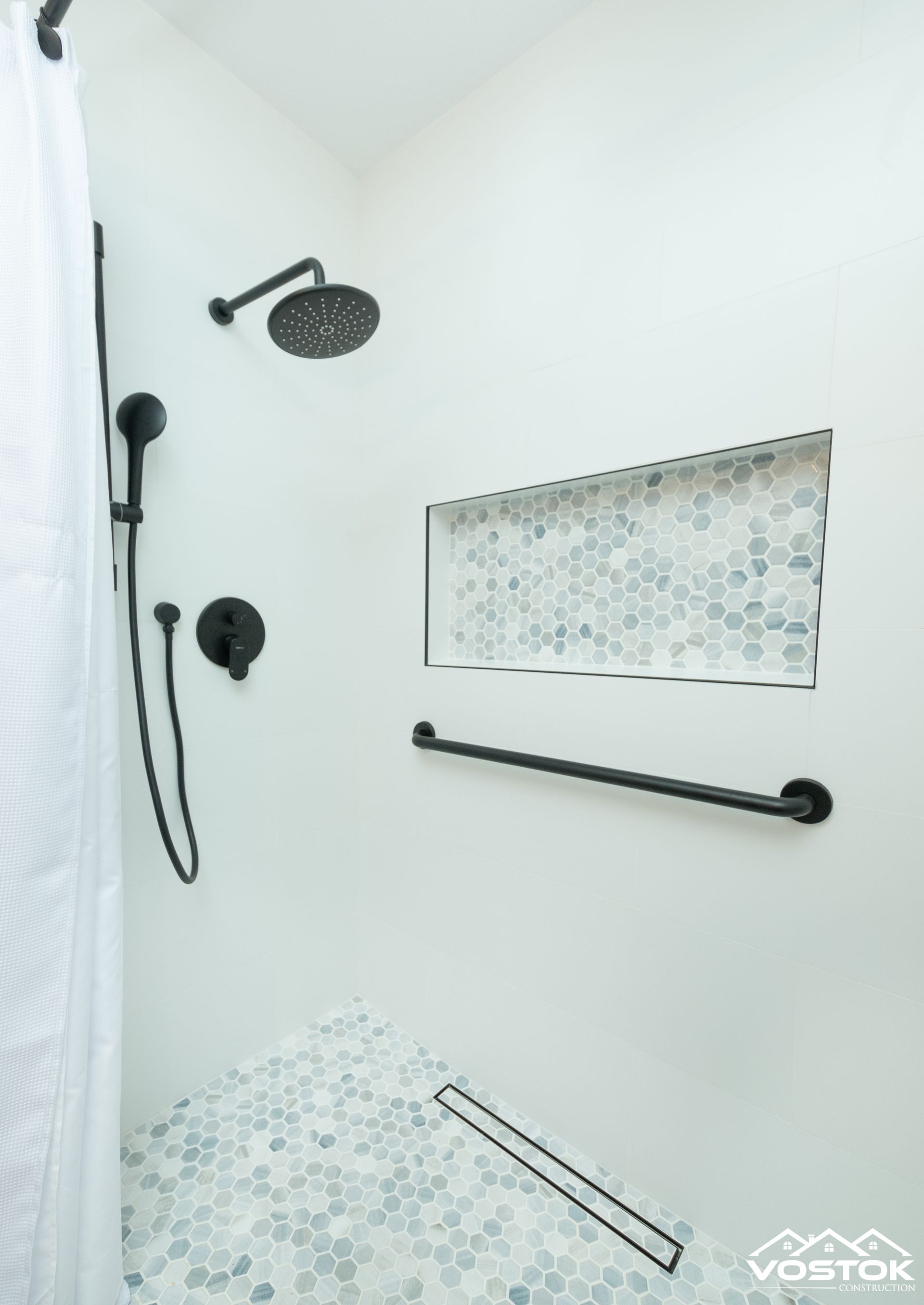A shower with two shower heads and a shelf in the wall.