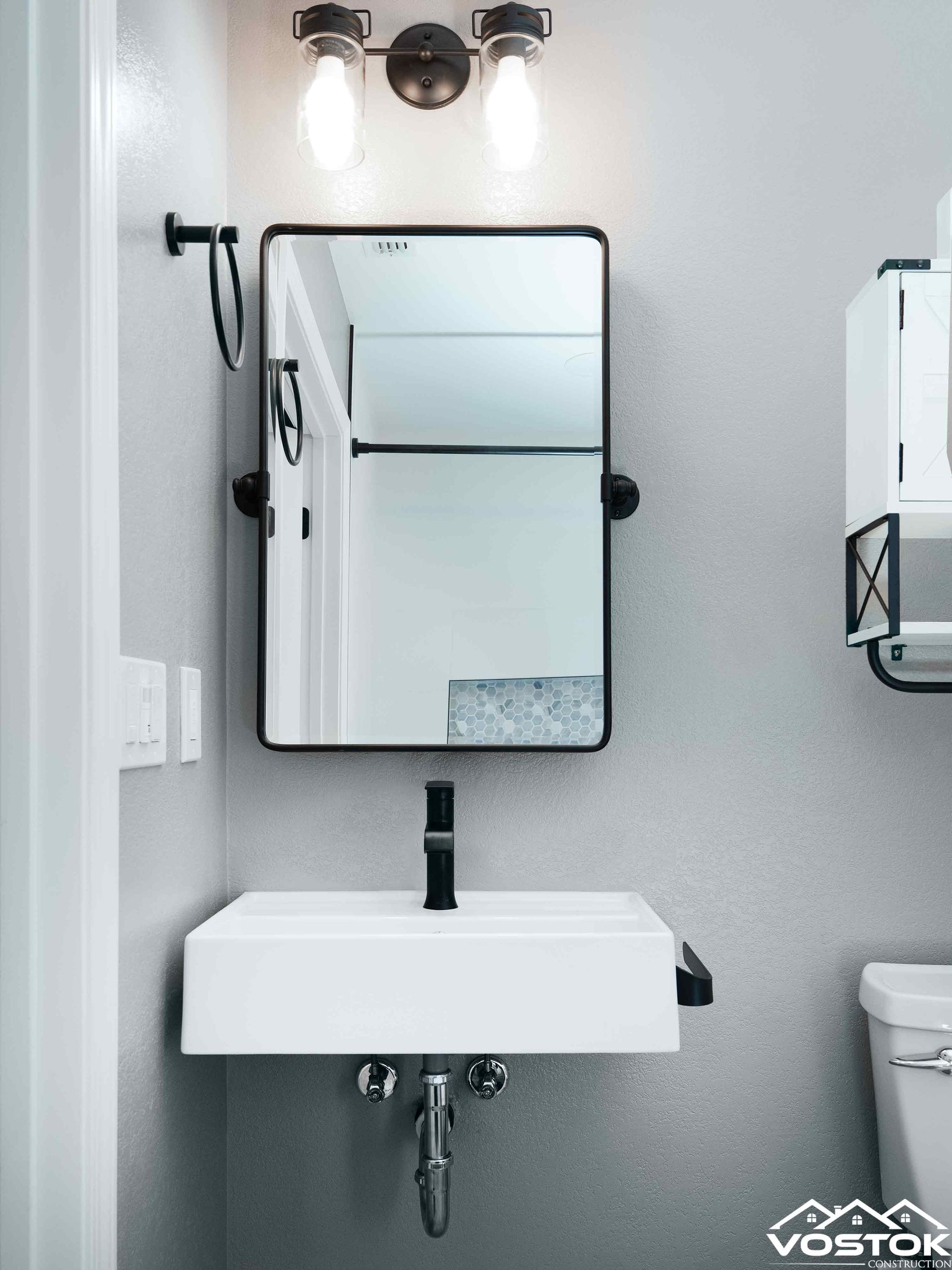 A bathroom with a sink , mirror and toilet.