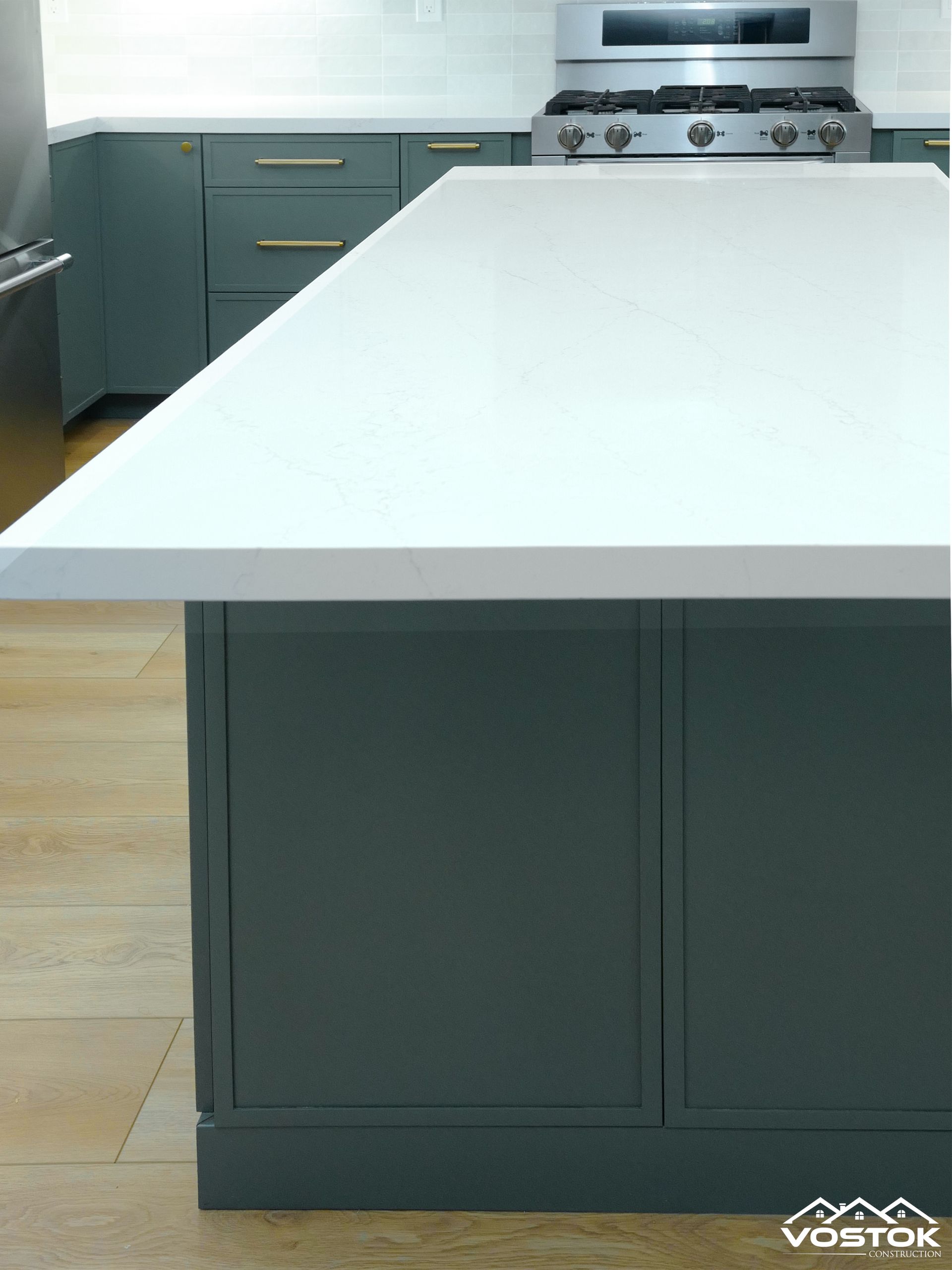 A kitchen with a large island and a stove top oven