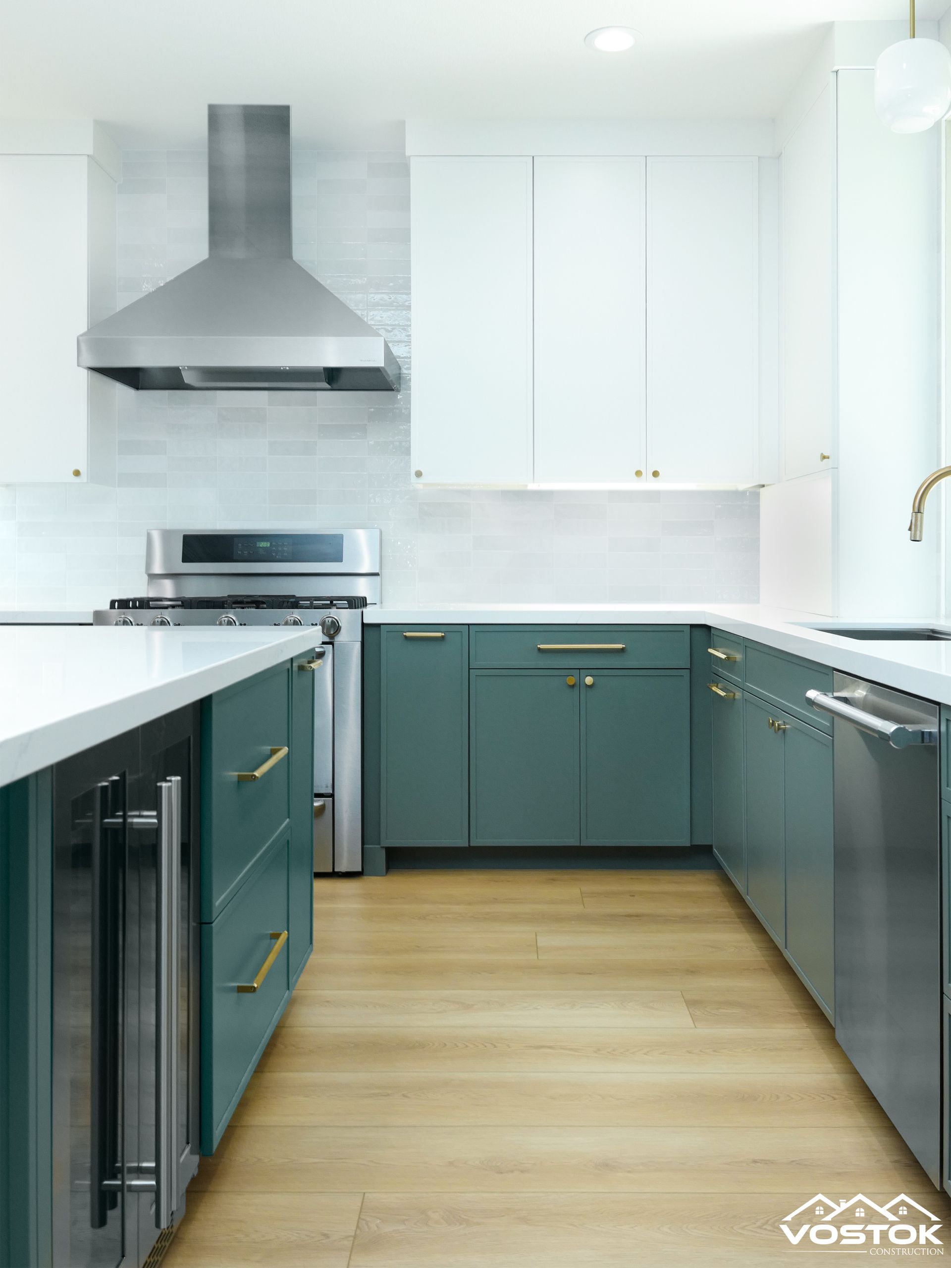 A kitchen with green cabinets , white cabinets , and stainless steel appliances.