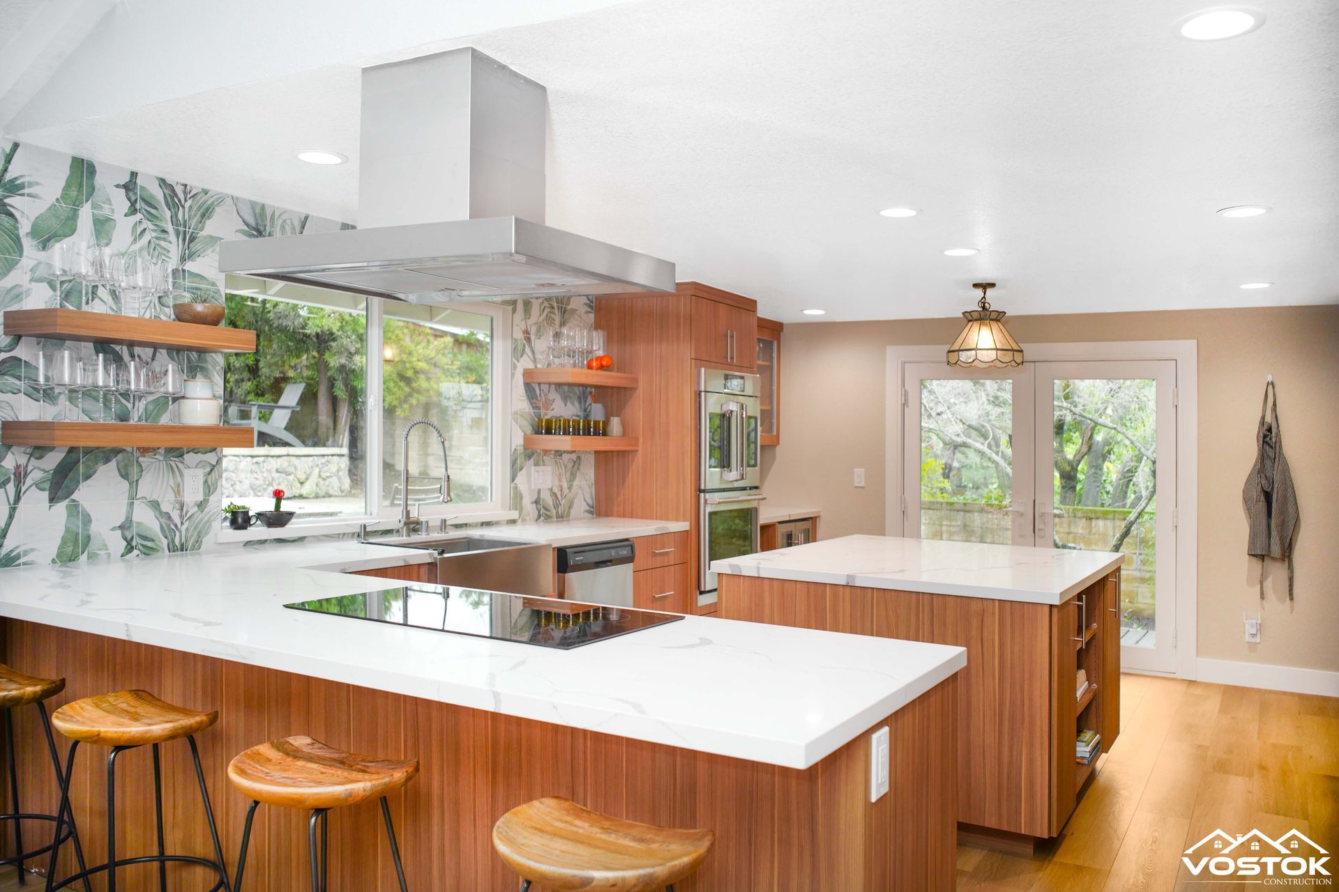 A kitchen with wooden cabinets , white counter tops , stainless steel appliances and a large island.