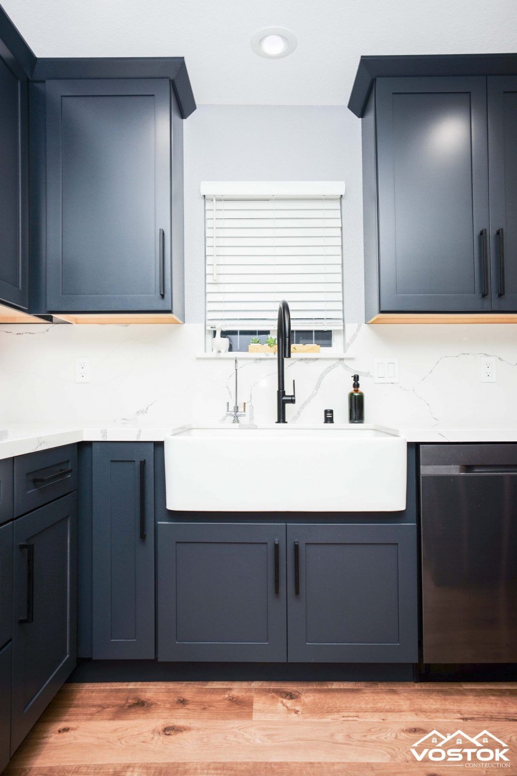 A kitchen with blue cabinets and a white sink.
