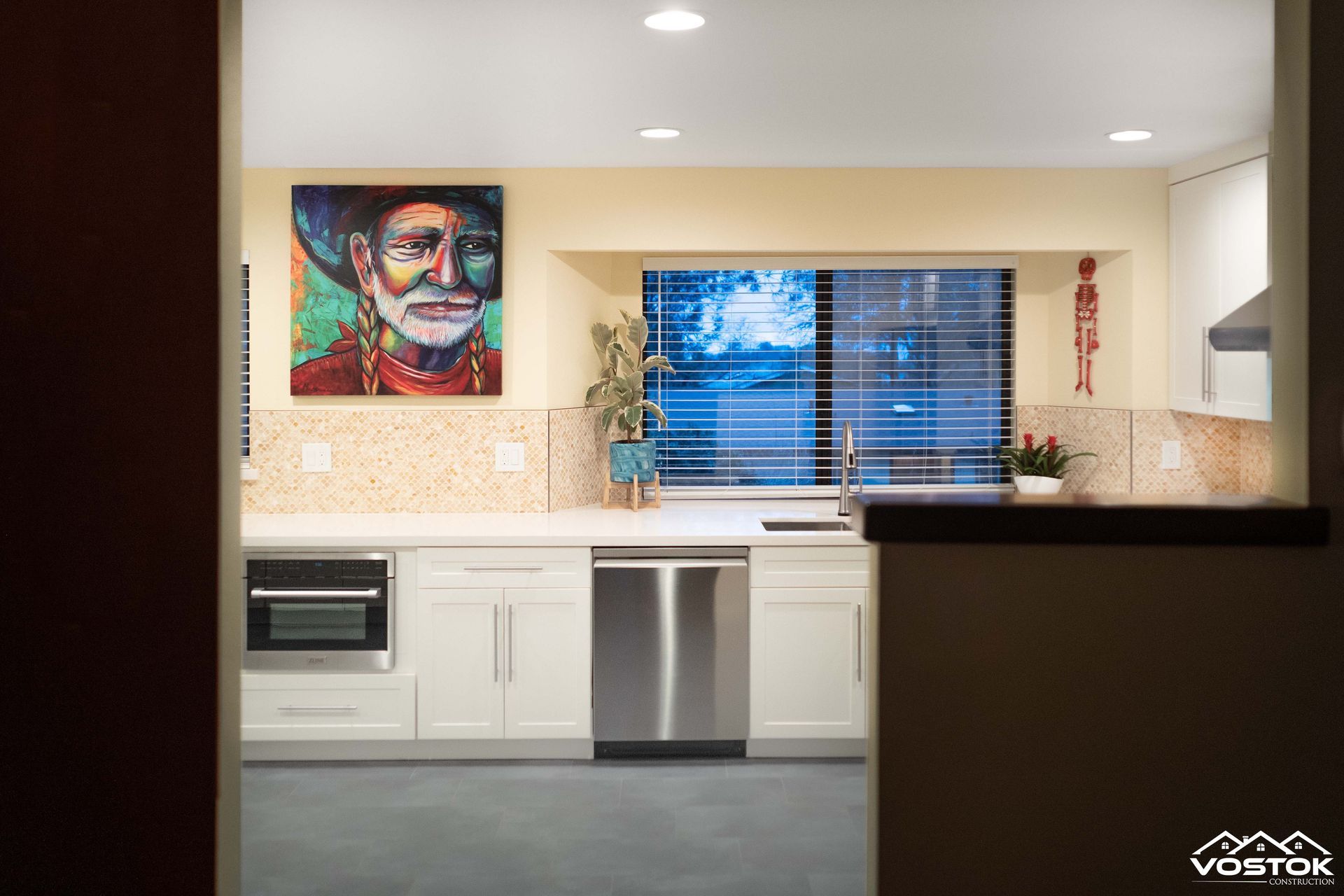 A kitchen with a painting of a cowboy on the wall.