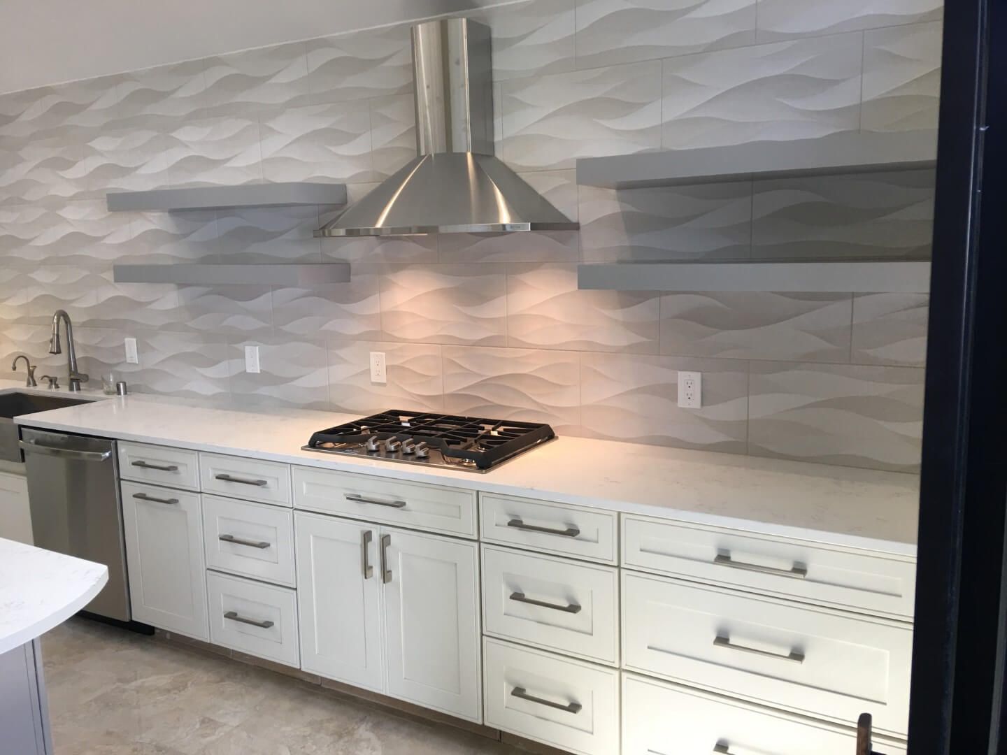 A kitchen with white cabinets and a stove top oven