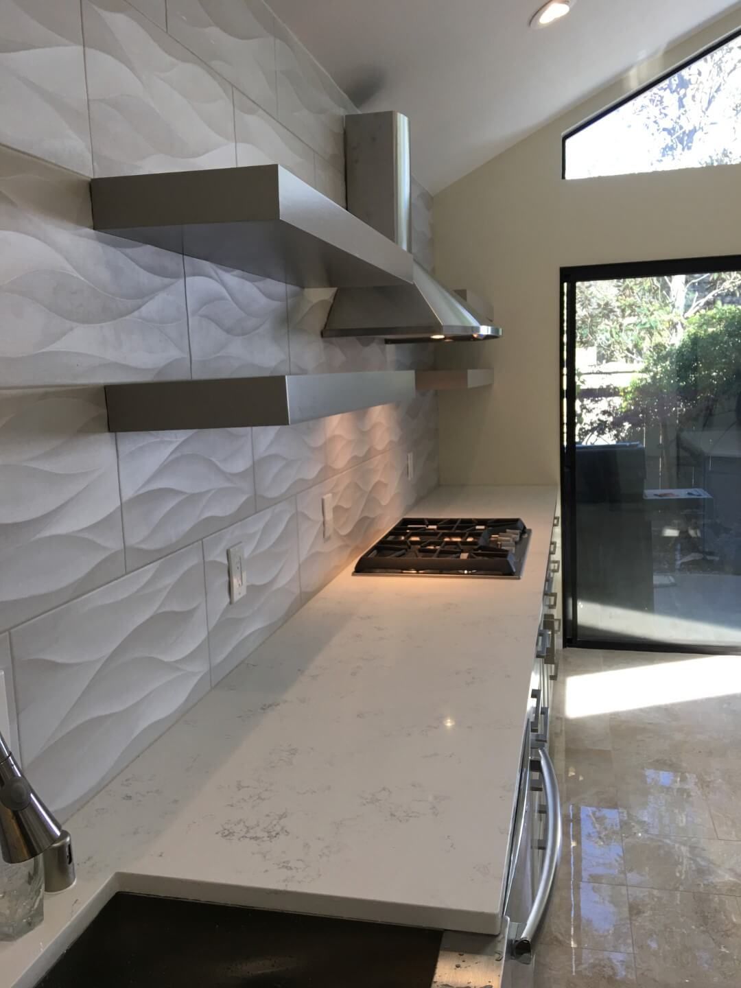 A kitchen with a stove top oven and stainless steel appliances