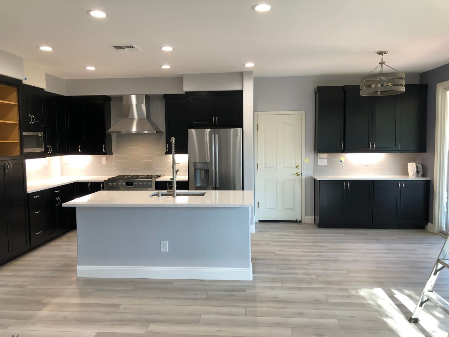 A kitchen with black cabinets and stainless steel appliances
