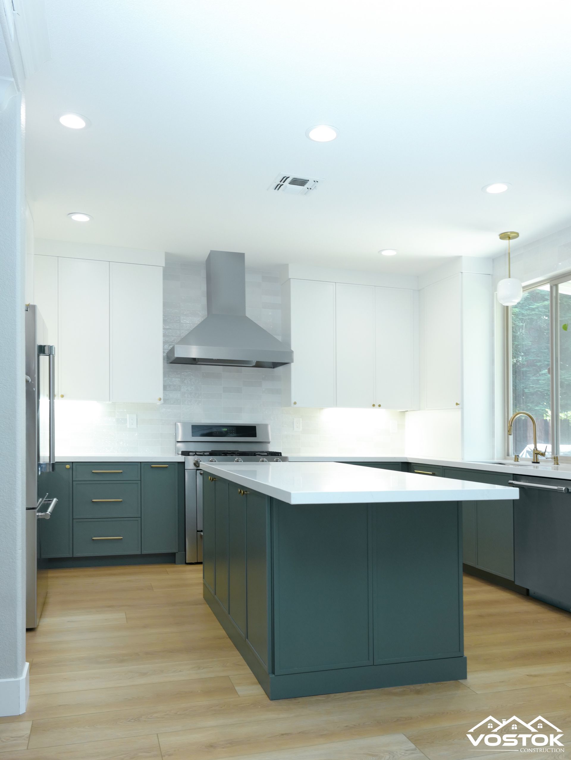 A kitchen with a large island and stainless steel appliances